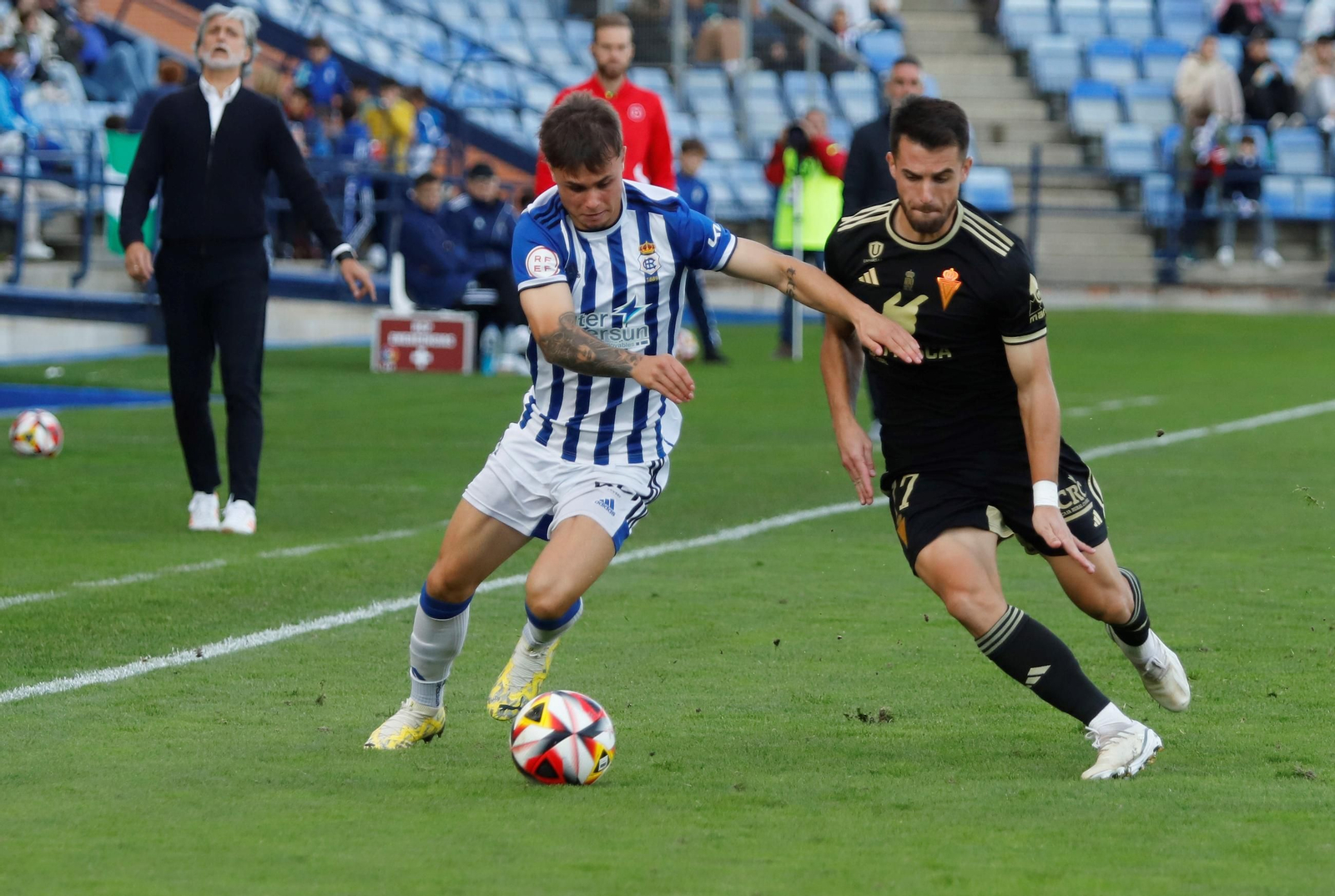 Dani Vega presiona a Sergio Díez que conduce el balón por la banda del Nuevo Colombino.