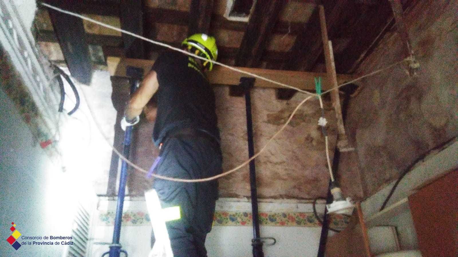 Bomberos trabajan en el falso techo de la vivienda tras el derrumbe.