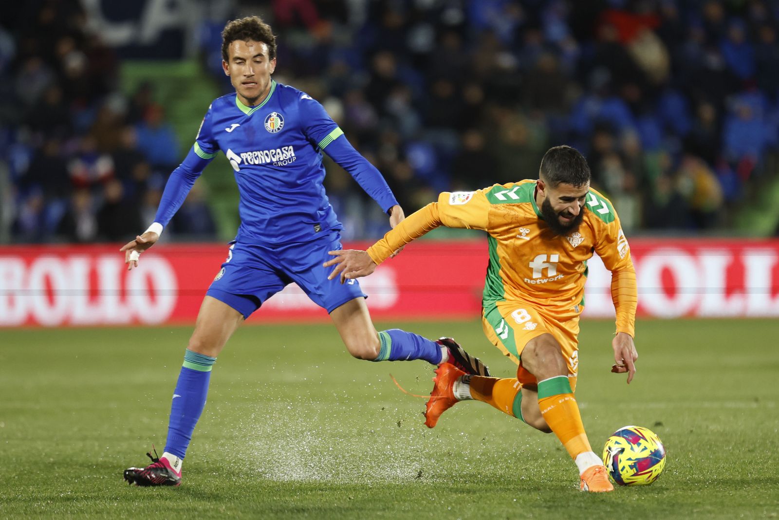 Luis Milla trata de robarle el balón a Fekir.