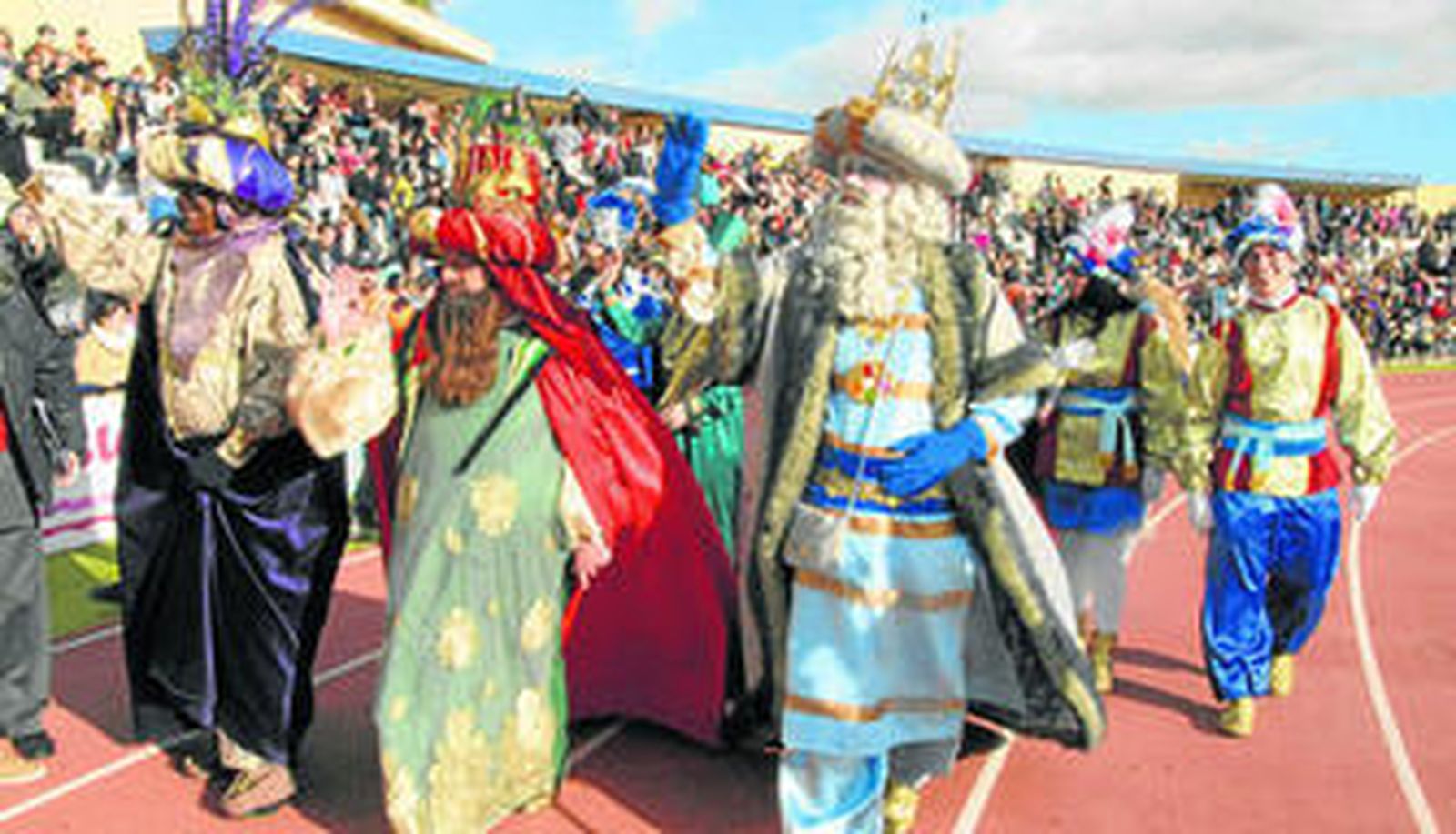 Los Reyes Magos, la Estrella de Oriente y el Heraldo Real, junto a una comitiva, saludan al público del Estadio Iberoamericano tras su llegada en helicóptero.