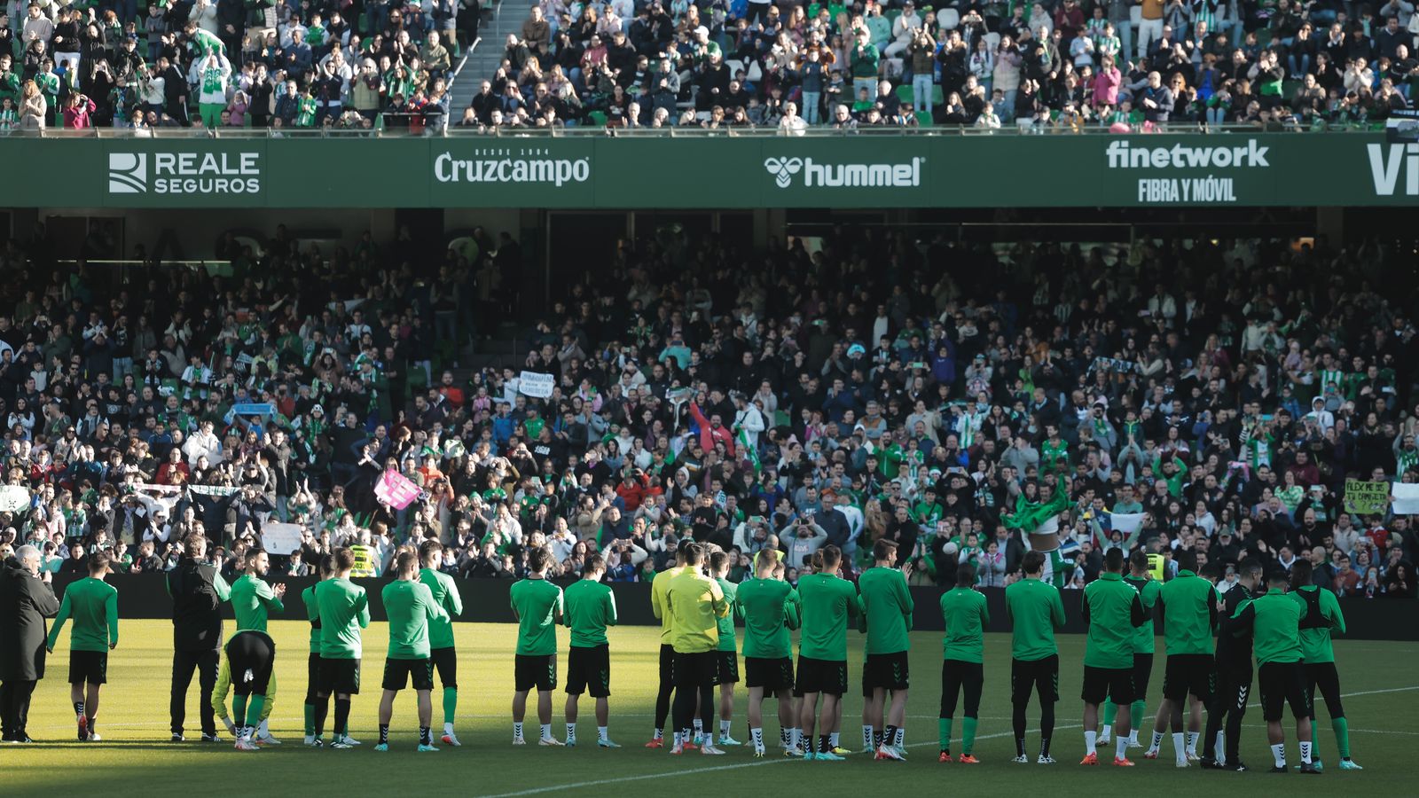 Los jugadores escuchan a la afición cantar el himno del Betis.