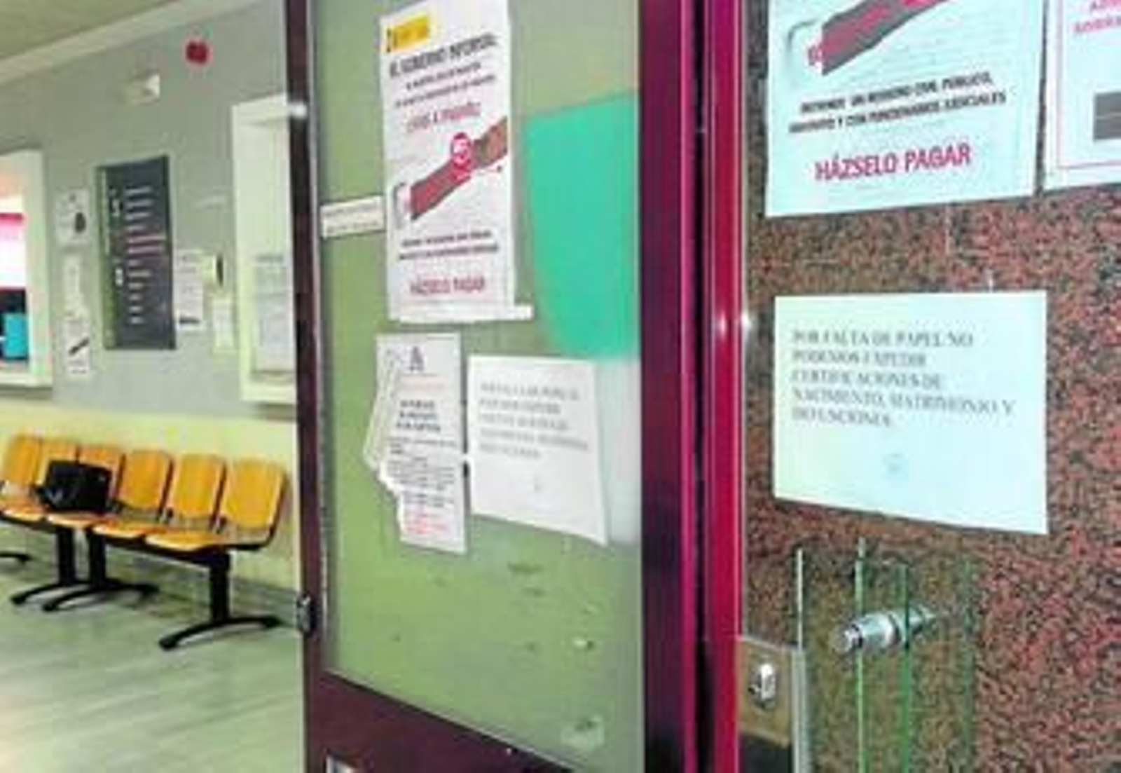 Carteles informando de la falta de papel a la entrada del Registro Civil.