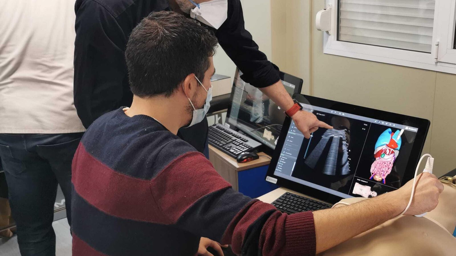 El doctor Alberto Oviedo instruyendo a un profesional en ecografía abdominal con simulación virtual.