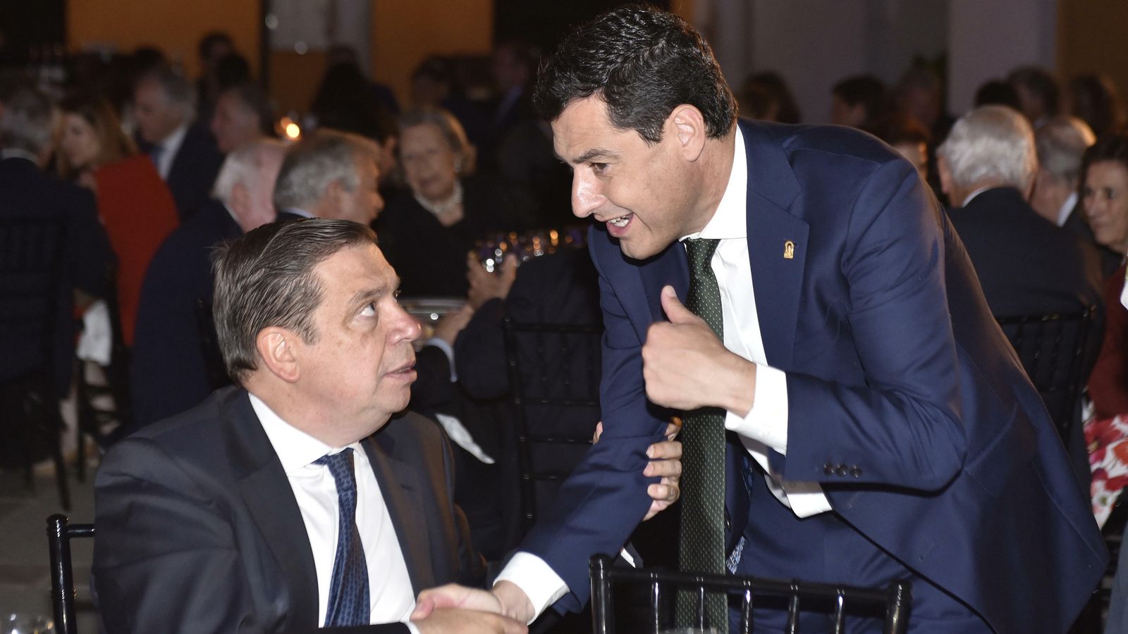 El presidente de la Junta de Andalucía, Juanma Moreno, saluda al ministro de Agricultura, Luis Planas.