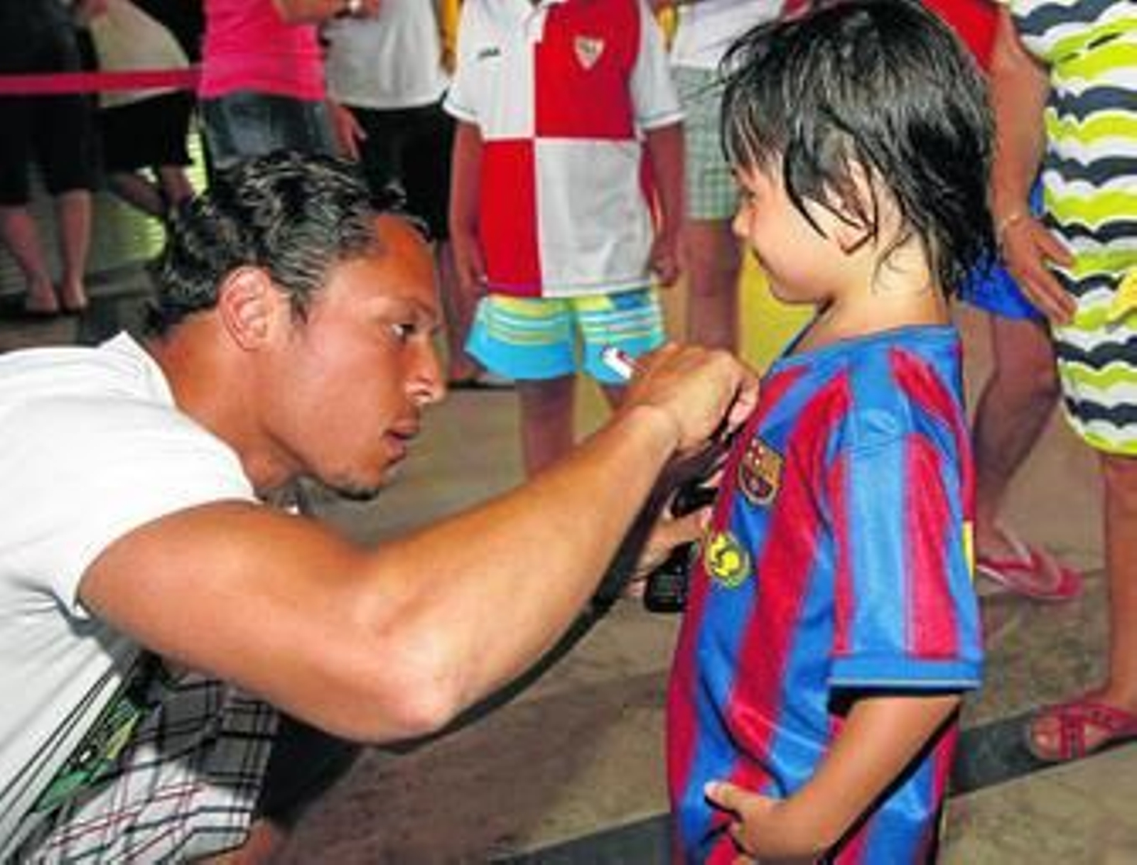 Adriano firma un autógrafo en la camiseta de un pequeño admirador de Iniesta que se dio cita por el hotel Elba Costa Ballena.