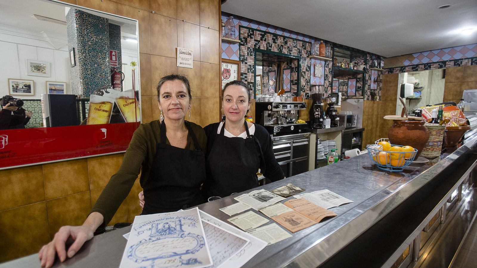 Natalia y Cristina, tras la barra con los recortes de prensa y otros archivos históricos