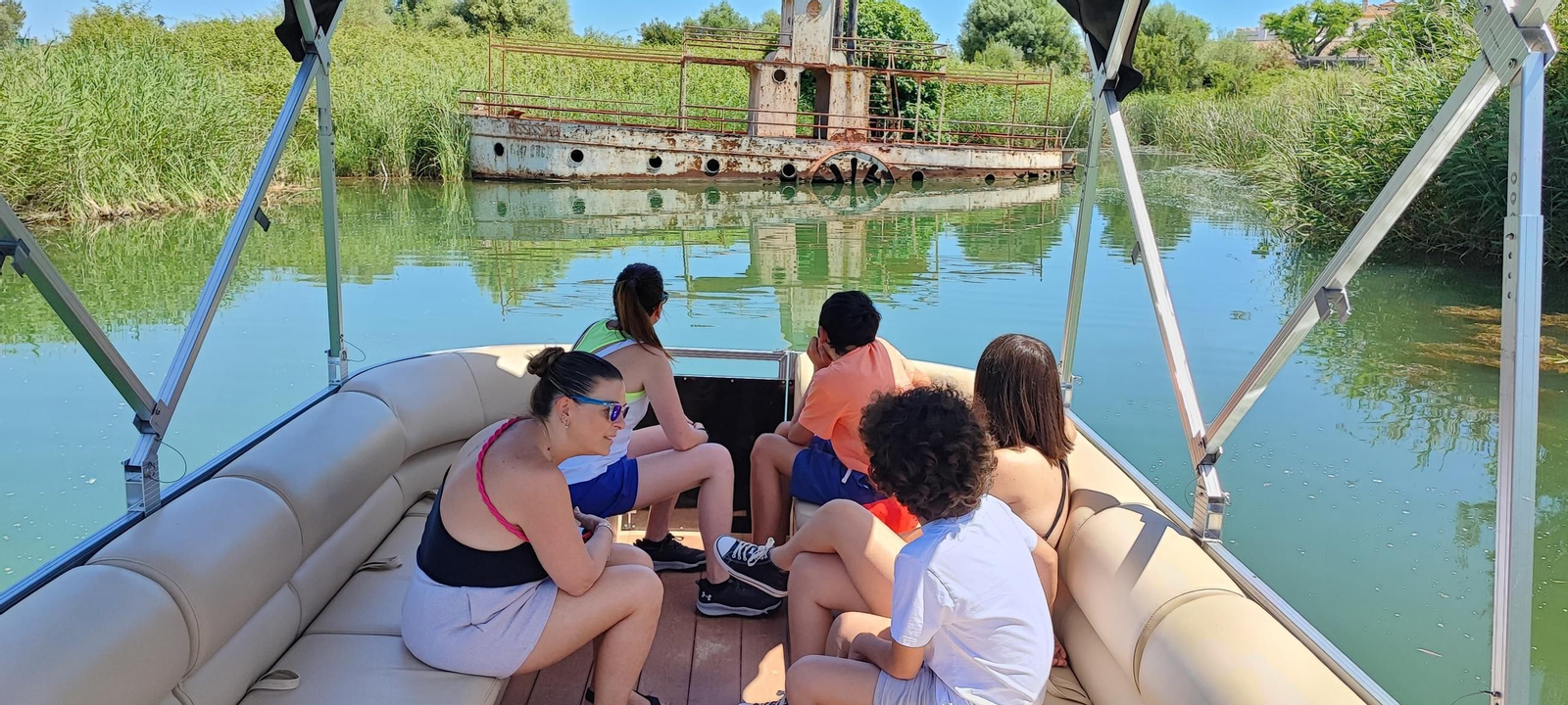 Un grupo de personas en un paseo por el lago de Arcos en una embarcación para llegar hasta el el famoso Mississippi semi hundido de La Molinera.