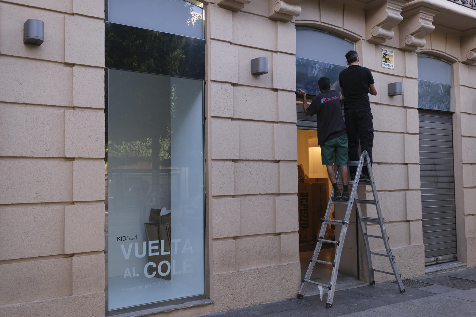 Los operarios retiran los letreros de Zara, con los escaparates ya vacíos