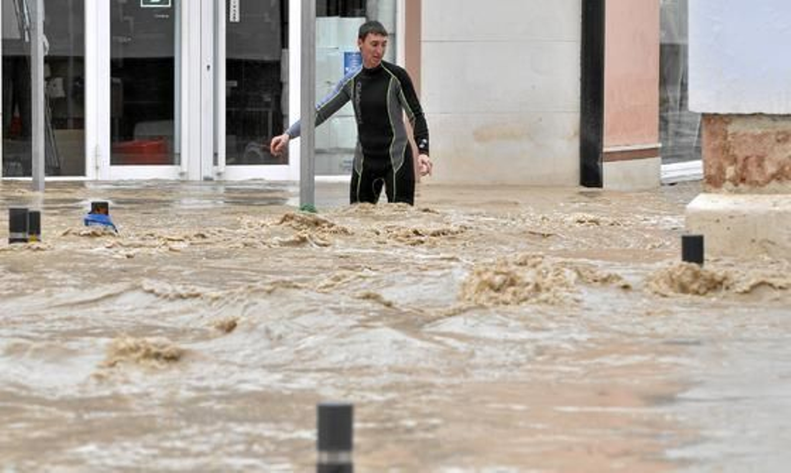 Un vecino, con traje de buzo, intenta caminar por la calle inundada. 

Foto: Manuel Gómez