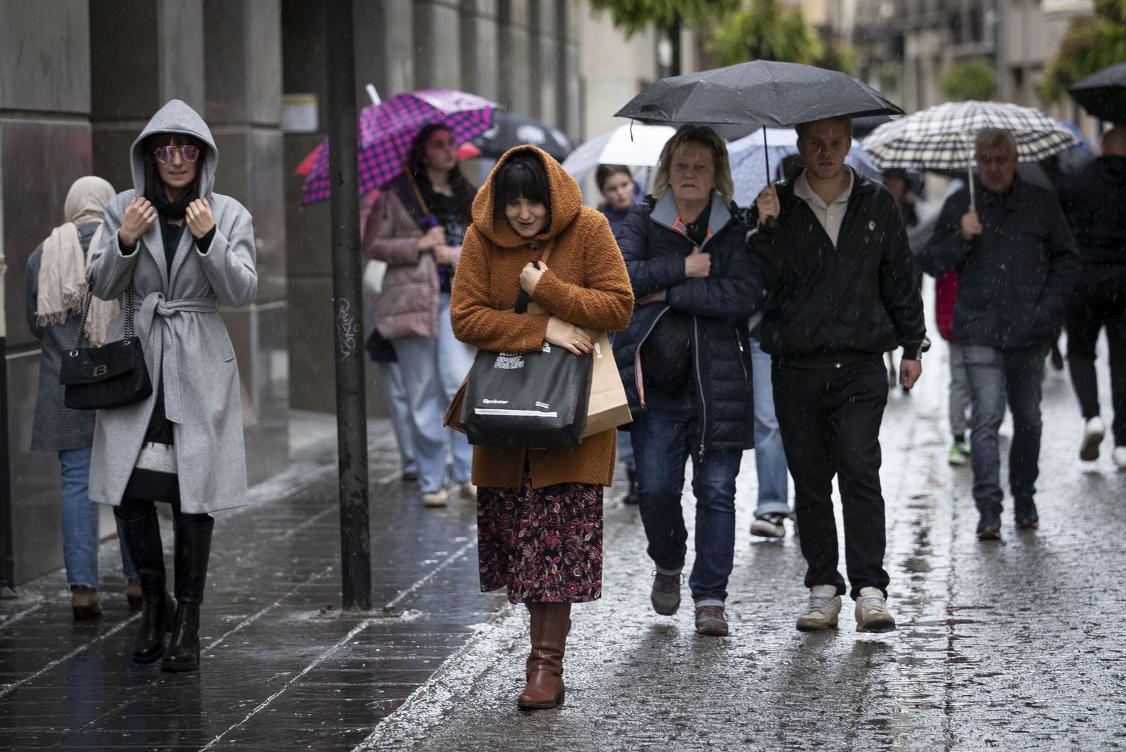 Varias personas se protegen de la lluvia en una imagen de archivo.