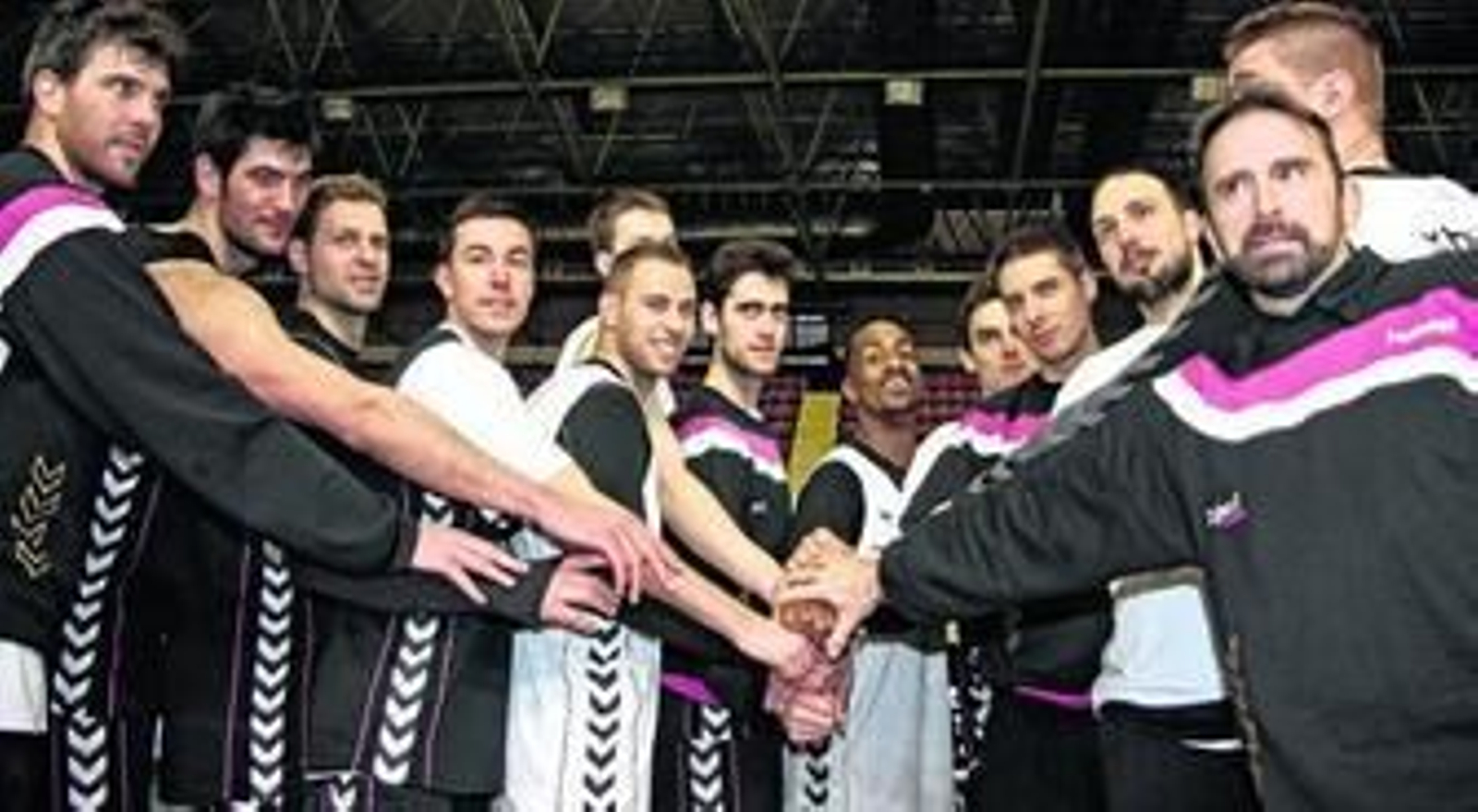 Los jugadores que conforman la plantilla cajista y Joan Plaza juntan sus manos como símbolo de unidad durante el día de puertas abiertas con los medios de comunicación.