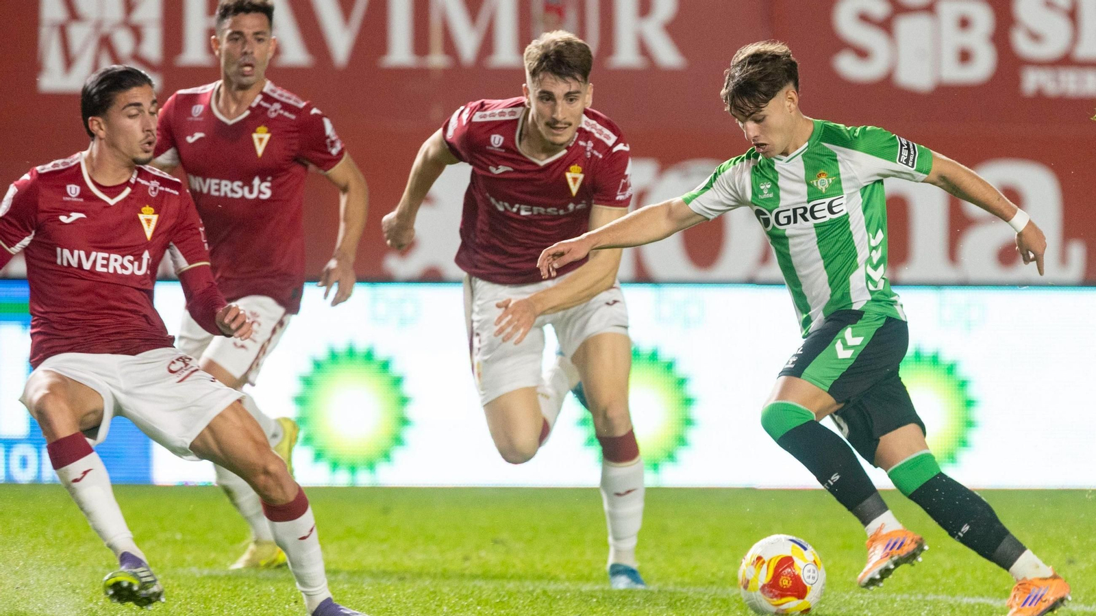 Ángel ortiz conduce el balón ante tres jugadores del Murcia.