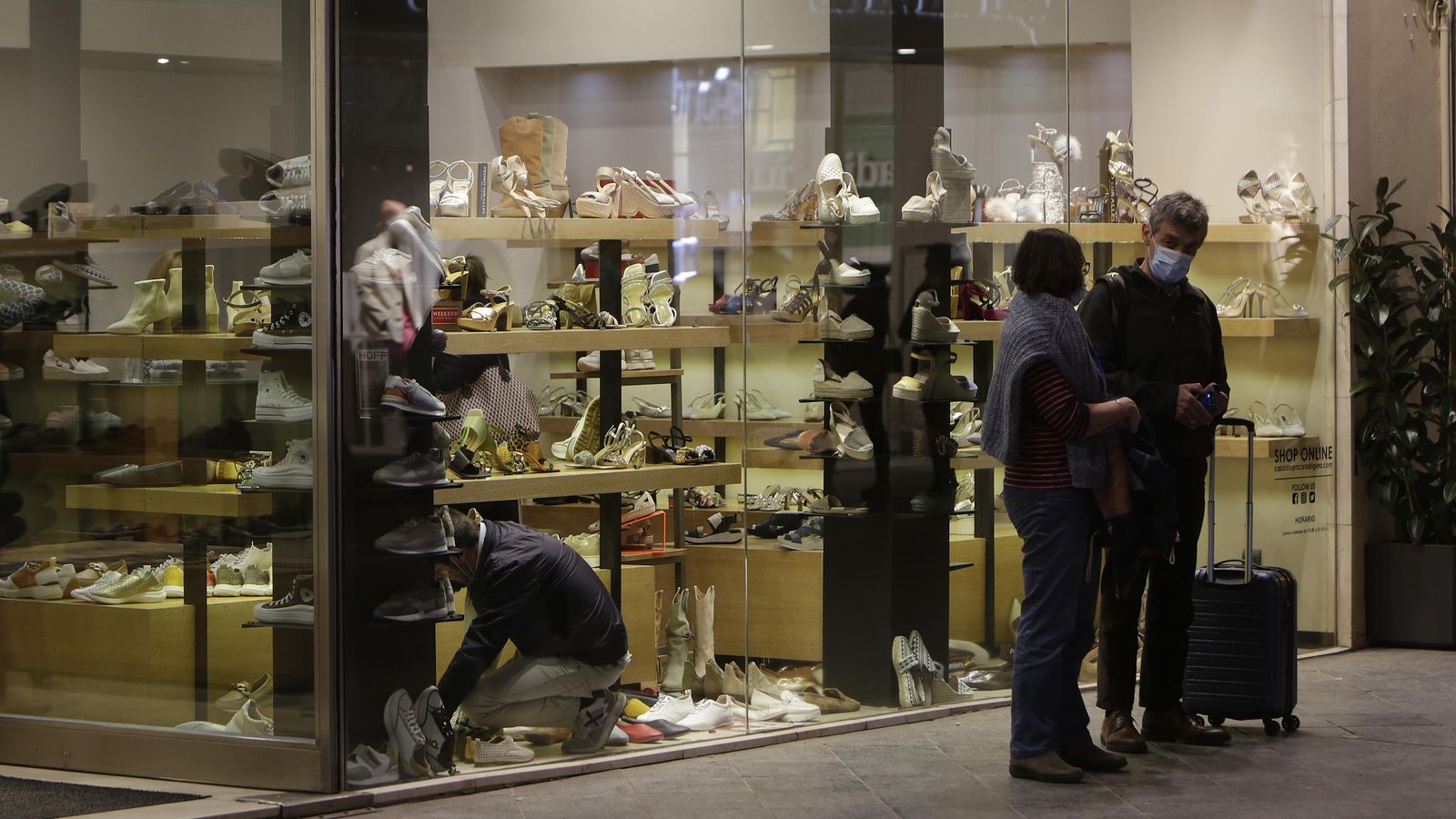 Turistas esperando delante de una zapatería.