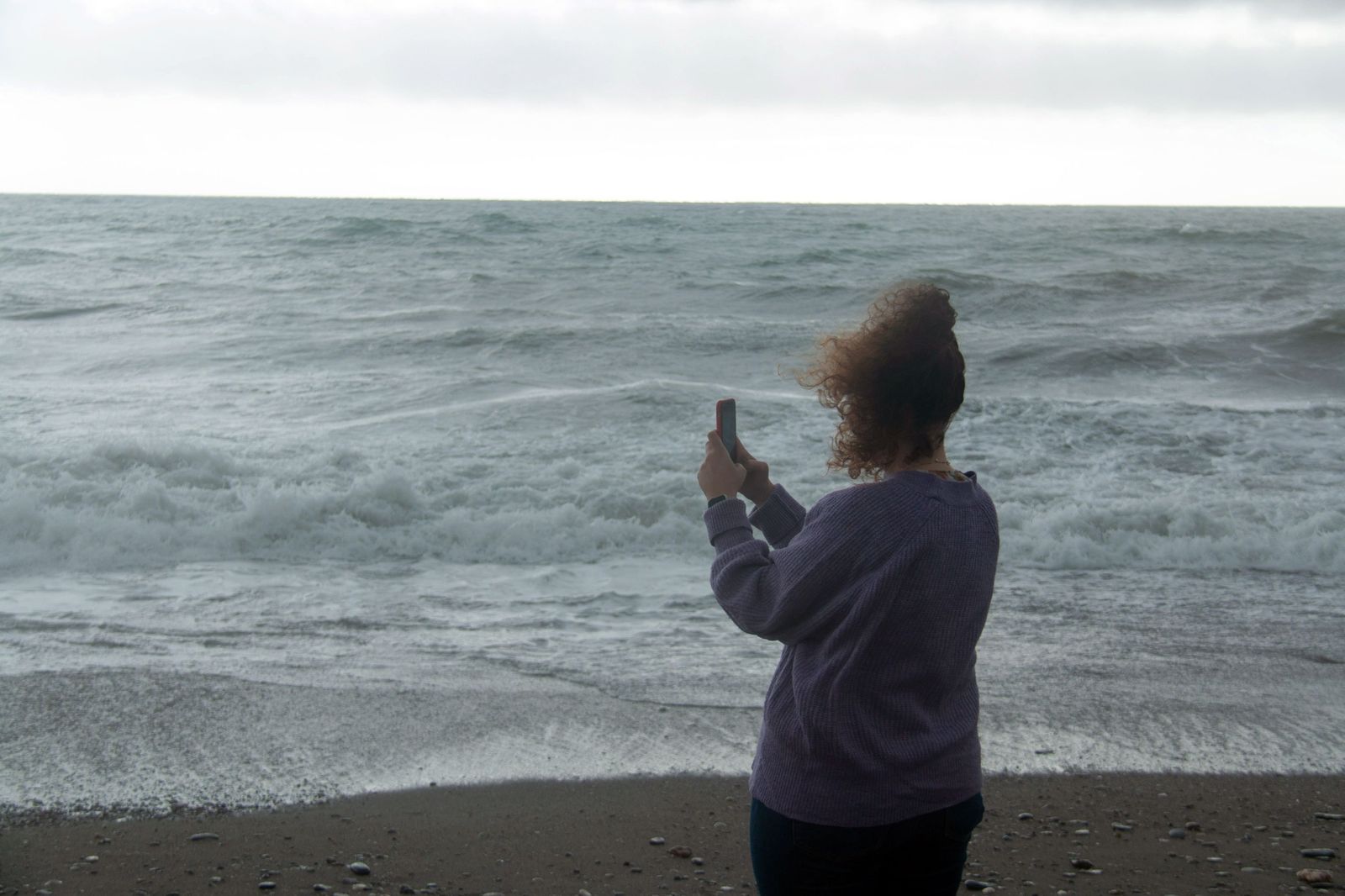 Mujer fotografiando el mar en la costa de Granada