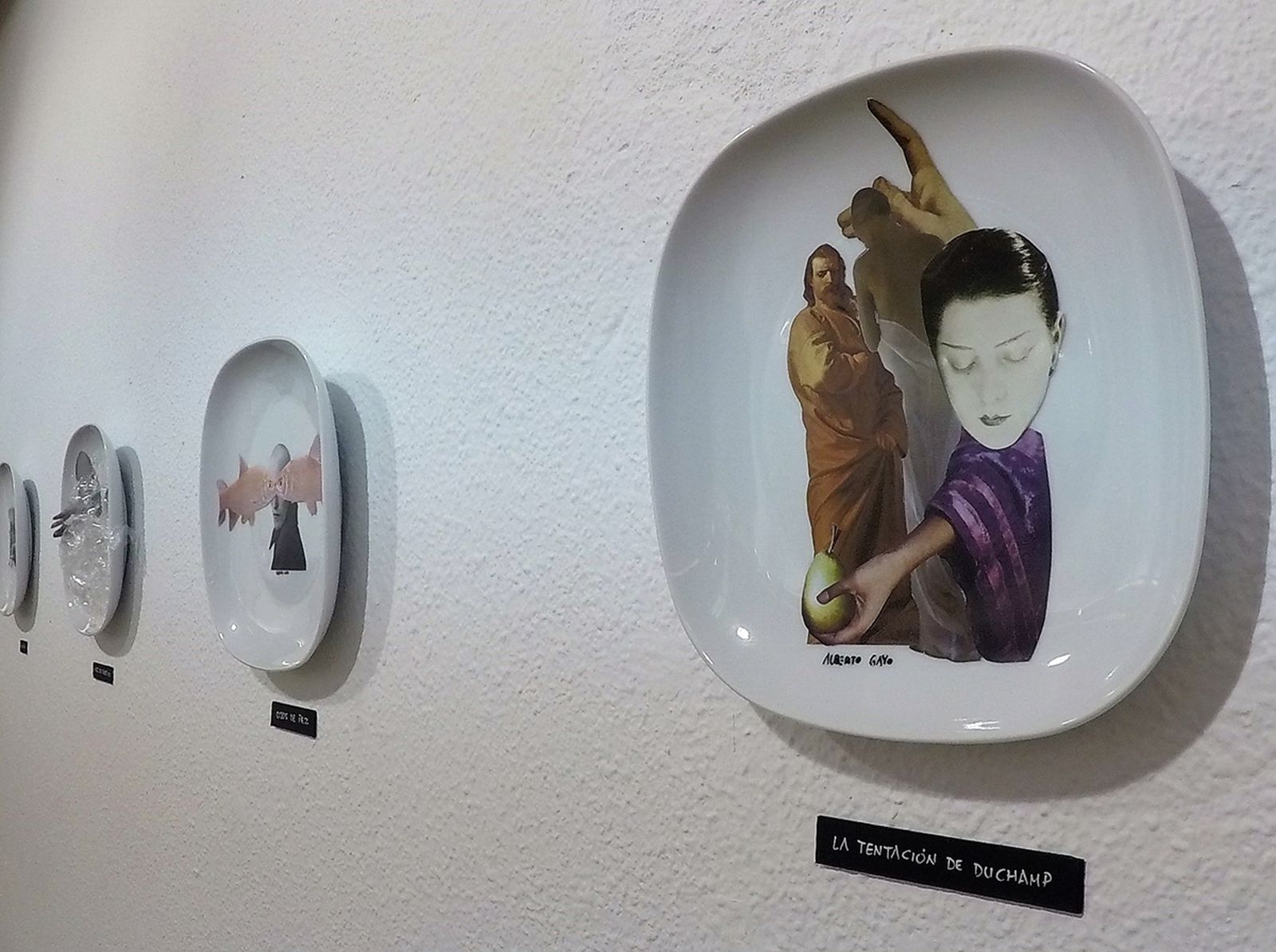 1. Obras del artista madrileño Alberto Gayo que permanecerán en la Biblioteca Municipal de Salobreña hasta el 14 de agosto . 2. El autor junto a sus platos collage convertidos es obras de arte de su serie 'Poemas visuales sobre loza' cuyo ingrediente principal es el primitivo ensamblaje dadaísta