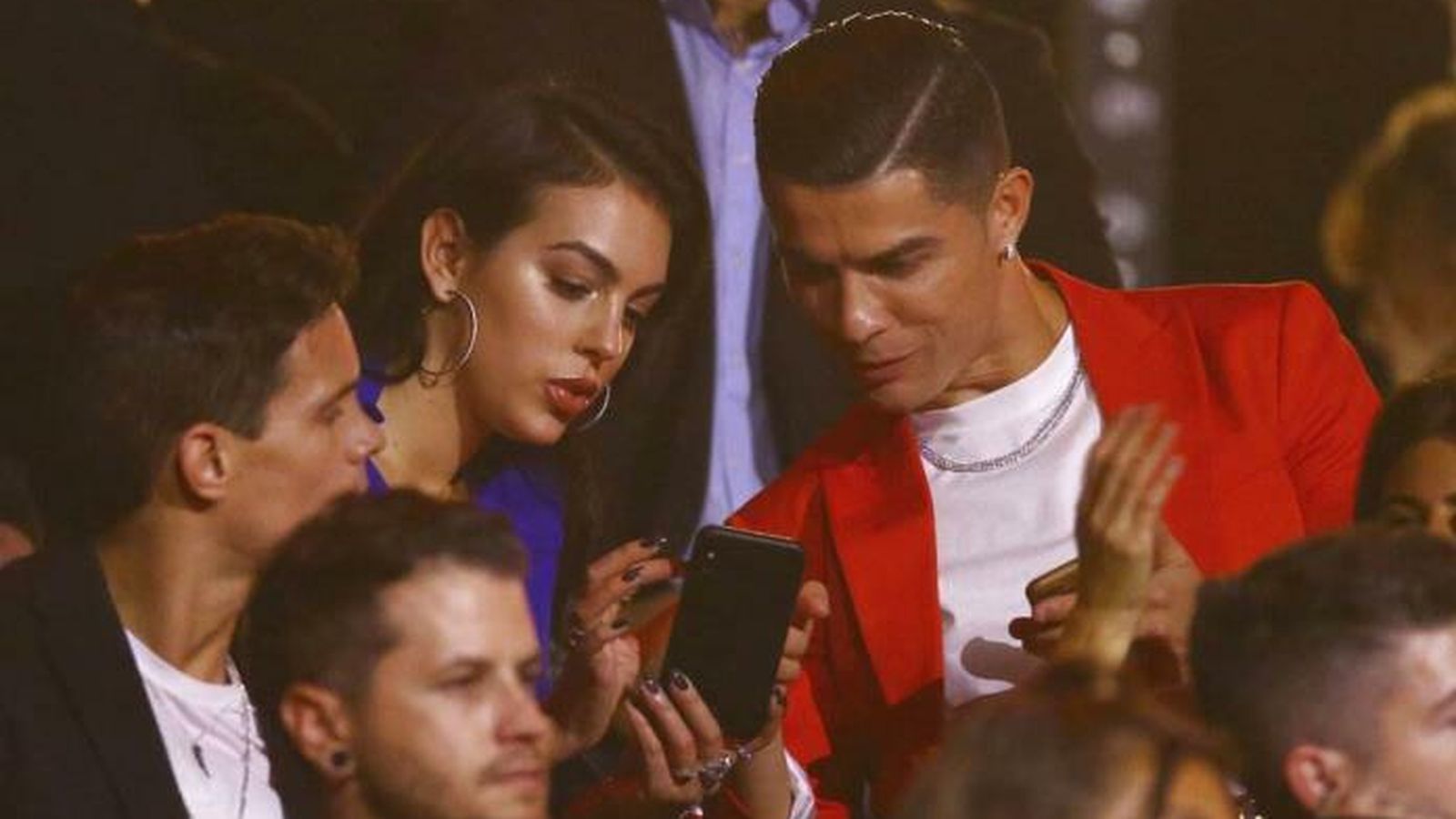 Georgina y Ronaldo, en la gala, cuando ella le muestra algo a él en el móvil.