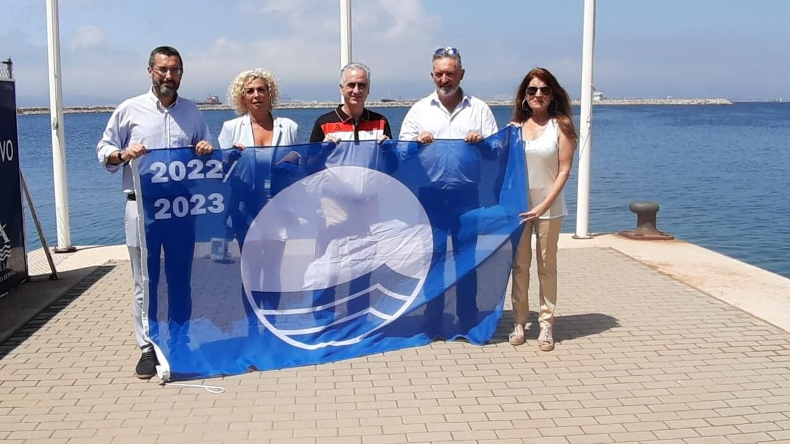 Los participantes en el acto de izado, con la bandera