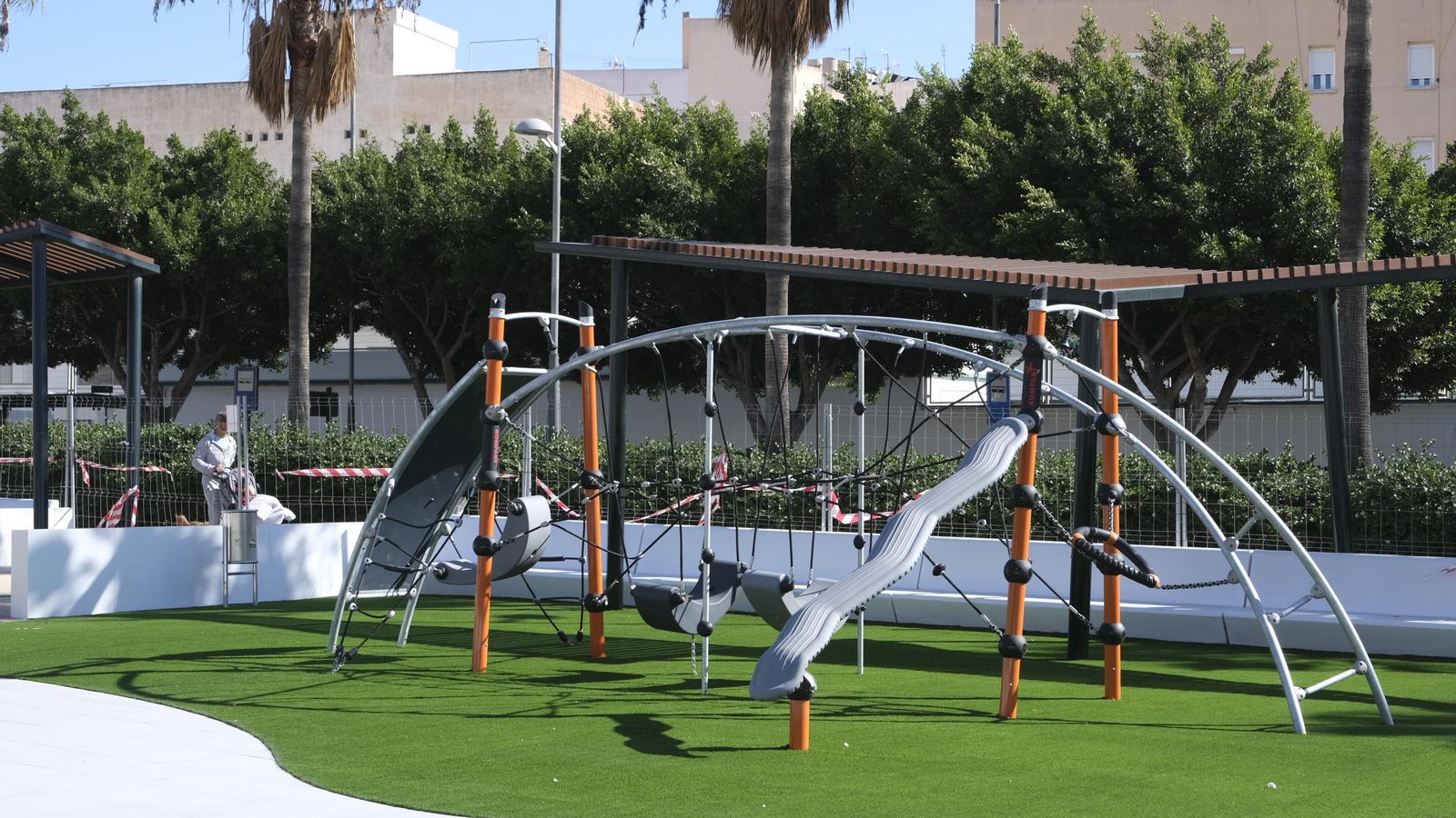 Conjunto de columpios sobre césped artificial.