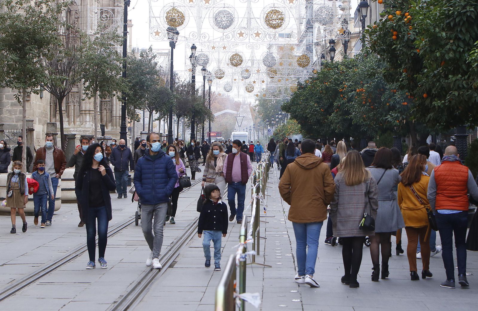 Decenas de personas de personas caminan por la avenida de la Constitución.