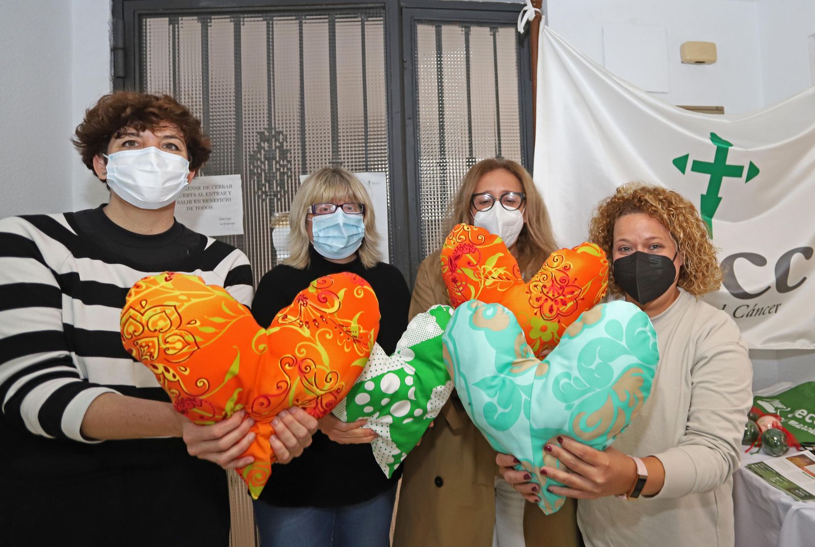 Personal de la delegación de la AECC de Huelva con cojines con forma de corazón.