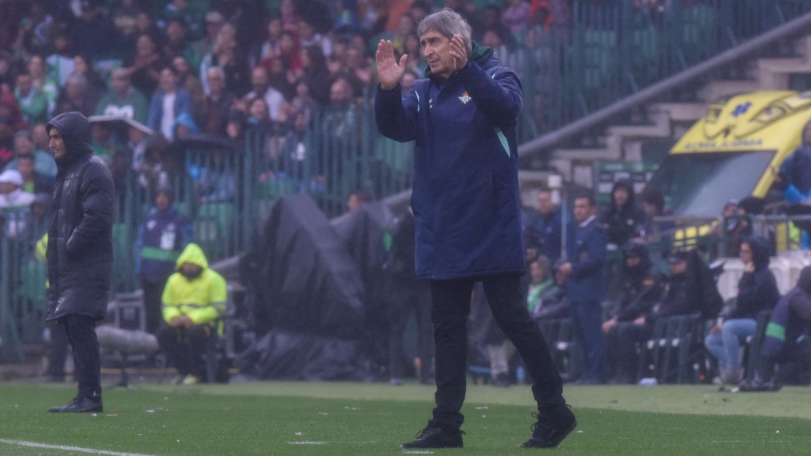 Pellegrini da instrucciones a sus jugadores bajo el aguacero en el Benito Villamarín.
