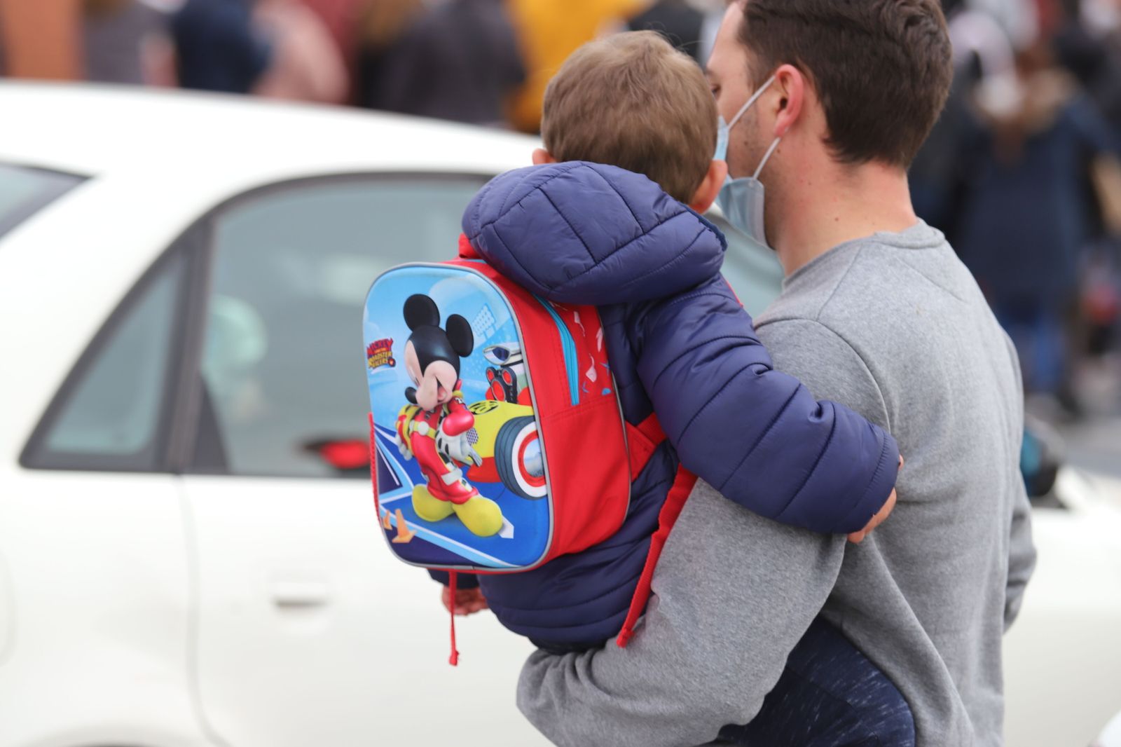 Un padre lleva a su hijo al colegio.
