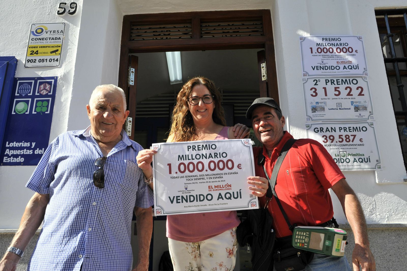 La dueña de la administración de Arcos junto a unos clientes celebrando el premio.