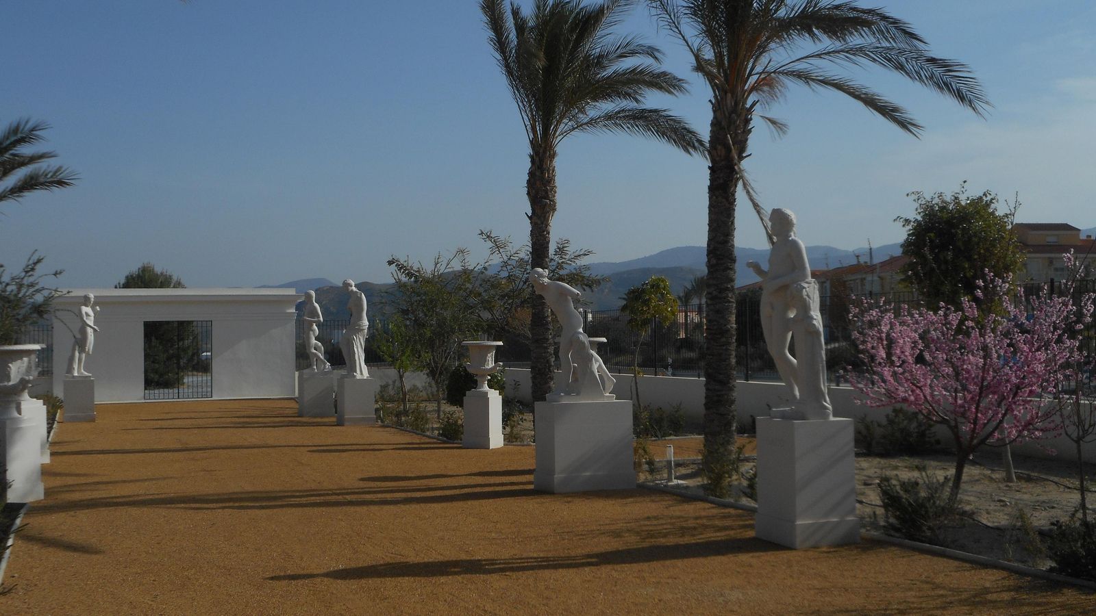 Jardín botánico y gliptoteca con esculturas grecorromanas que ejercen de transición entre el aparcamiento y la plaza del anillo museístico