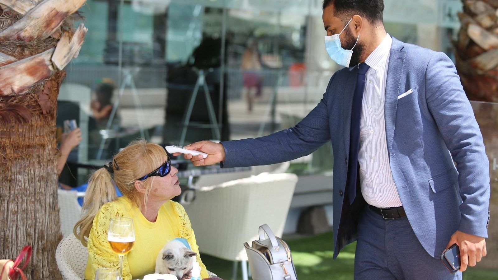 El jefe de sala mide la temperatura a una cliente en Kaleido Málaga Port.
