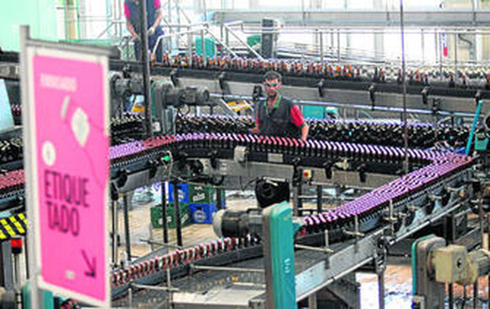 Un operario de la fábrica de cerveza San Miguel de la capital vigila el proceso de etiquetado.