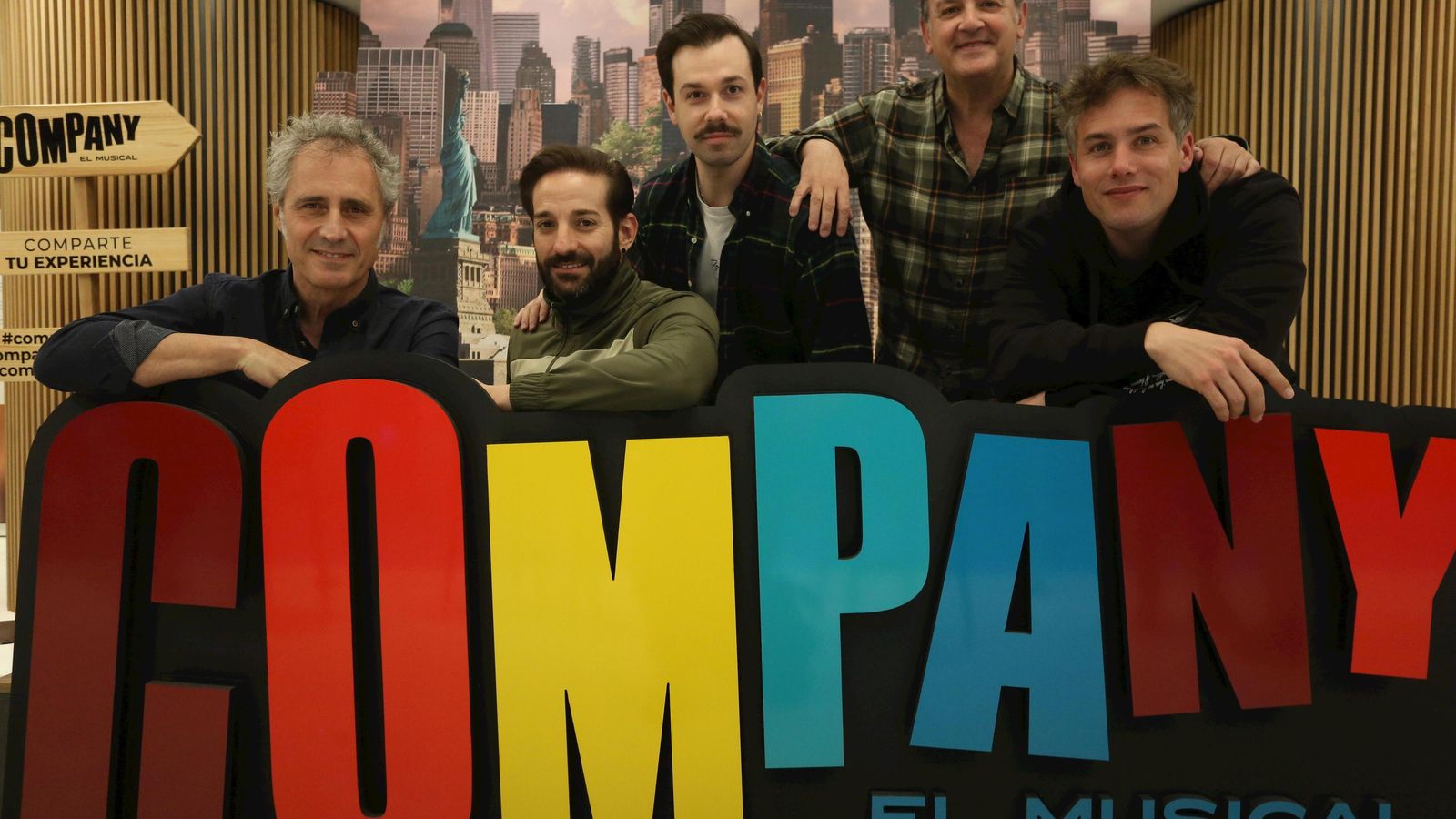 Los actores con el cartel de la obra.