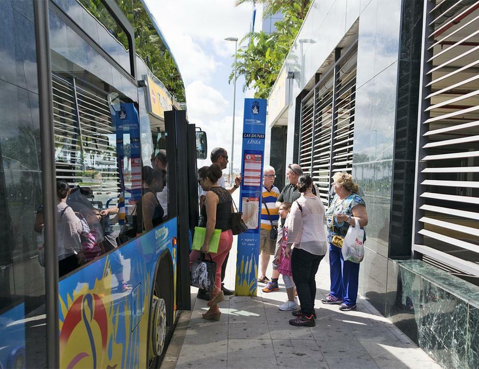 Usuarios del servicio junto a uno de los autobuses urbanos de Sanlúcar.