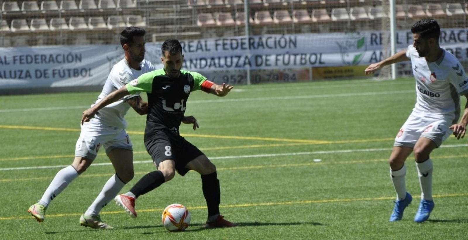 Mario Ruiz es presionado por dos jugadores del Utrera.