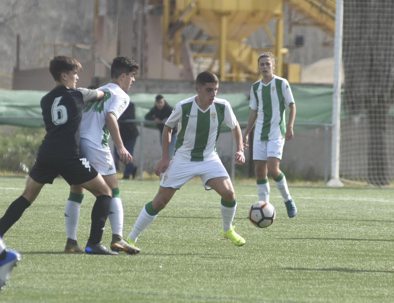 Un jugador del Córdoba trata de controlar el balón ante un compañero y un rival.