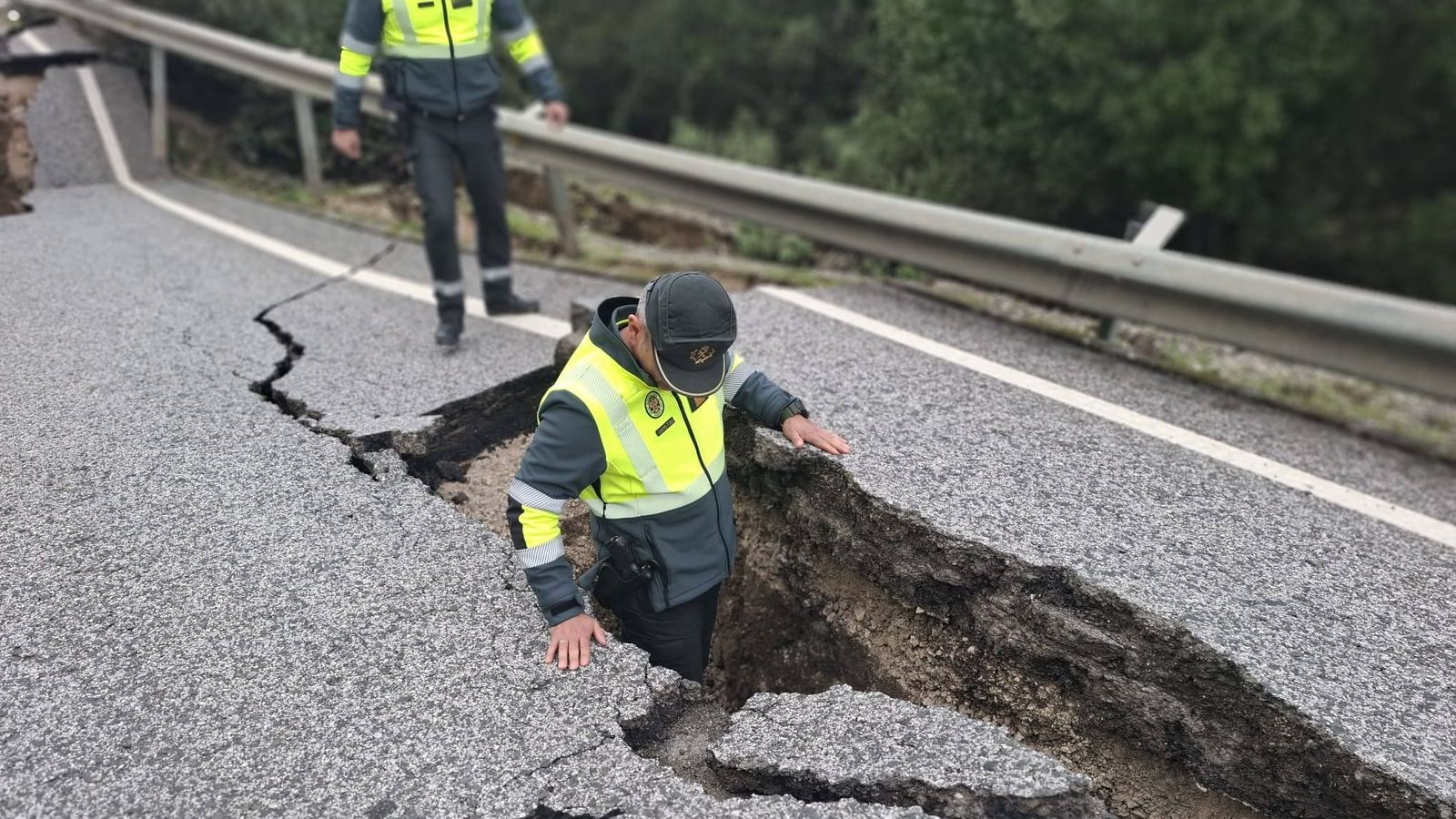 Un agente de Guardia Civil examina una de las carreteras afectadas por hundamientos en la provincia de Cádiz.