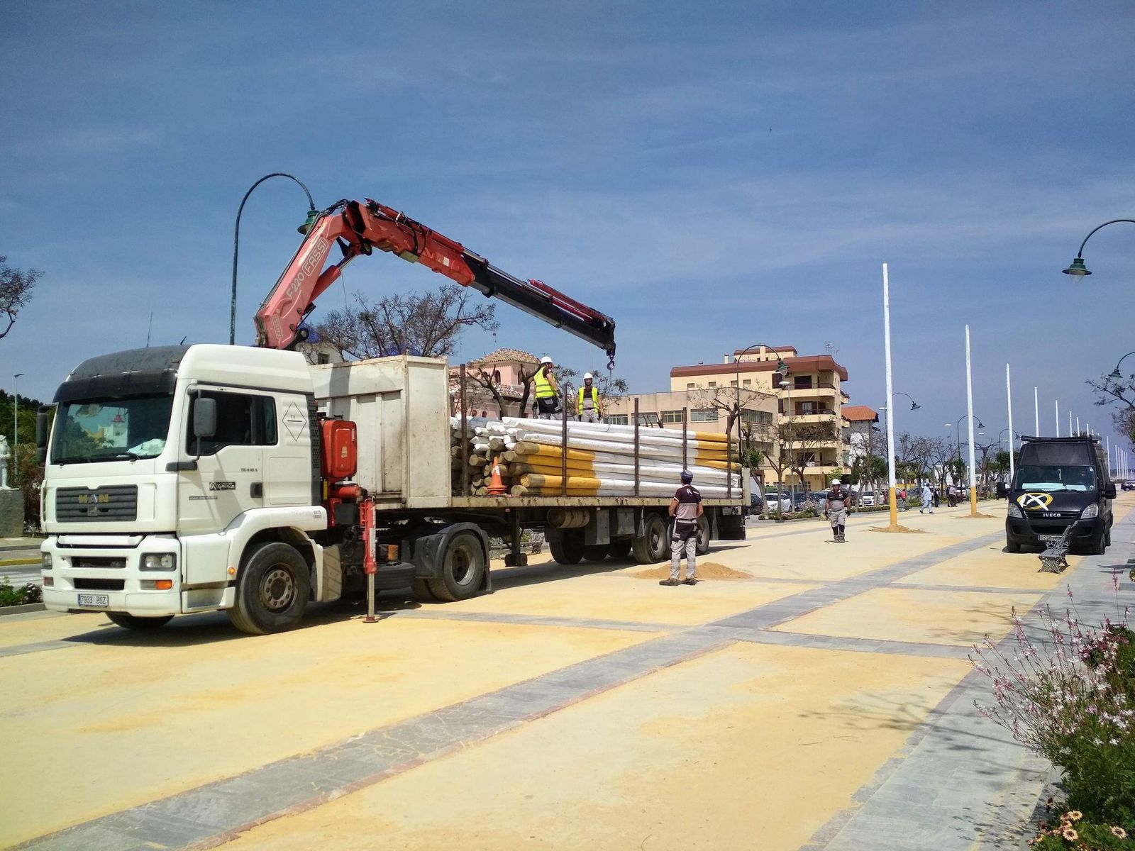 Trabajos de montaje de los postes del alumbrado de la Feria de la Manzanilla en el paseo de La Calzada.