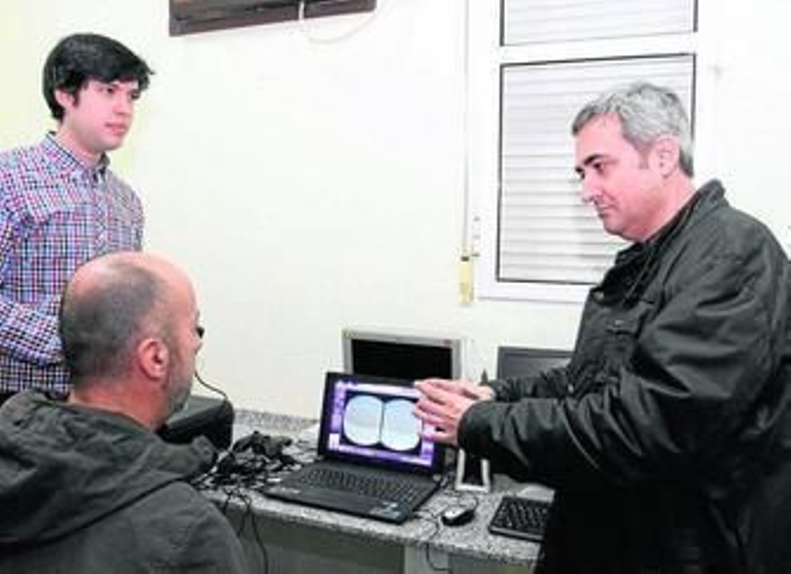 Enrique Moraleda explica a un voluntario en qué consiste el programa informático.