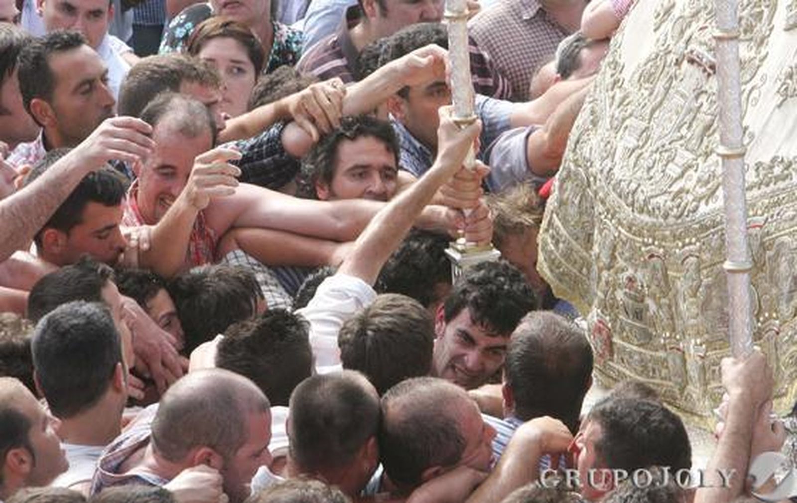 Romeros intentando agarrarse a los varales del paso de la Blanca Paloma.

Foto: Pascual