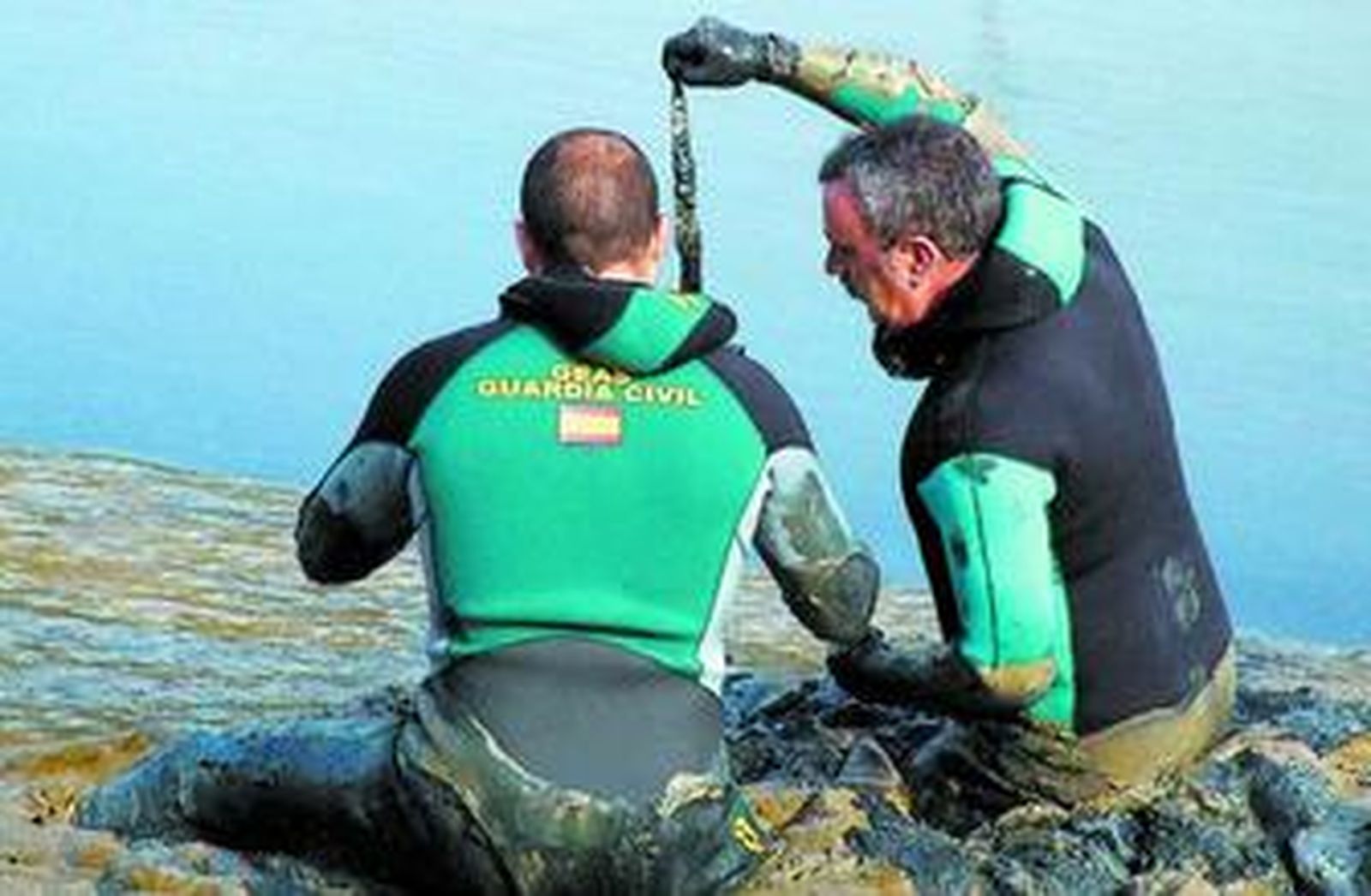 Unos buzos de la Guardia Civil recuperan el cuchillo del crimen.