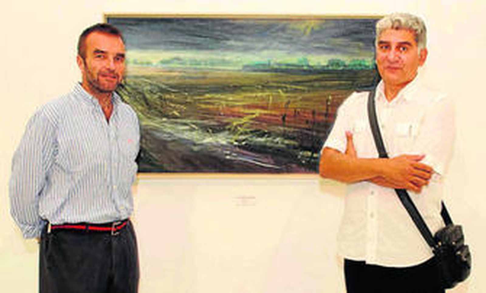 El pintor Juan Carmona y el concejal de Cultura Millán Alegre junto a una de las obras de la muestra.