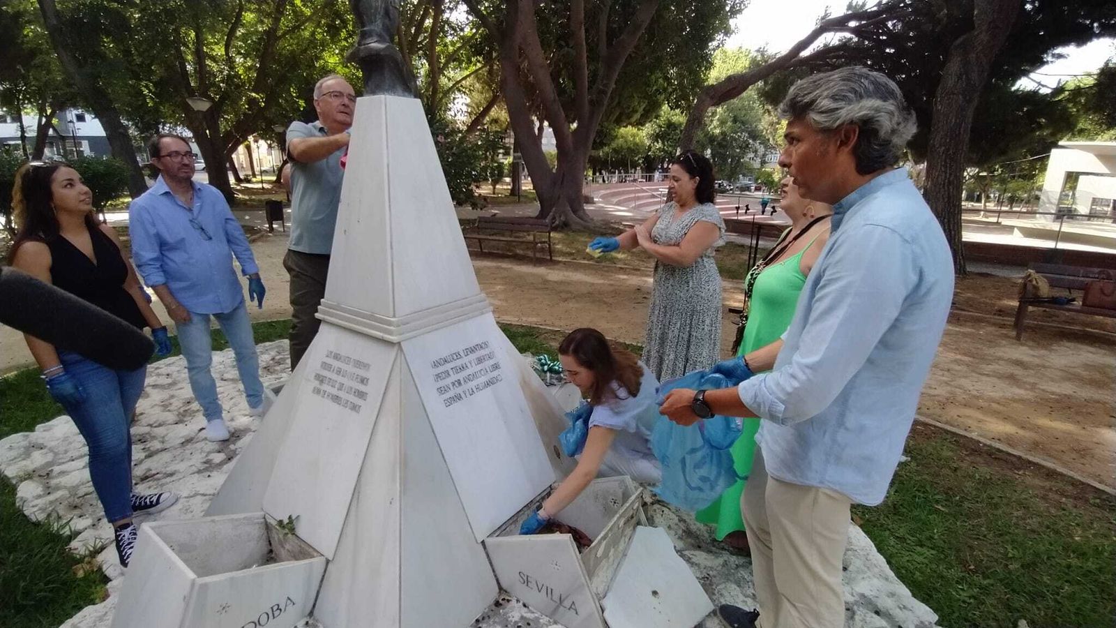 Miembros de AxSí limpian y retiran la basura acumulada del monumento a Blas Infante.