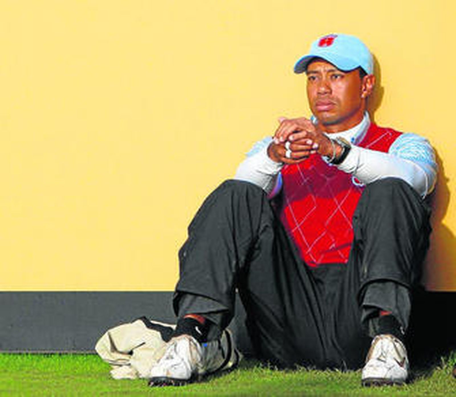 Tiger Woods, sentado en el césped en los aledaños el hoyo 18, reflexiona tras su mal juego.