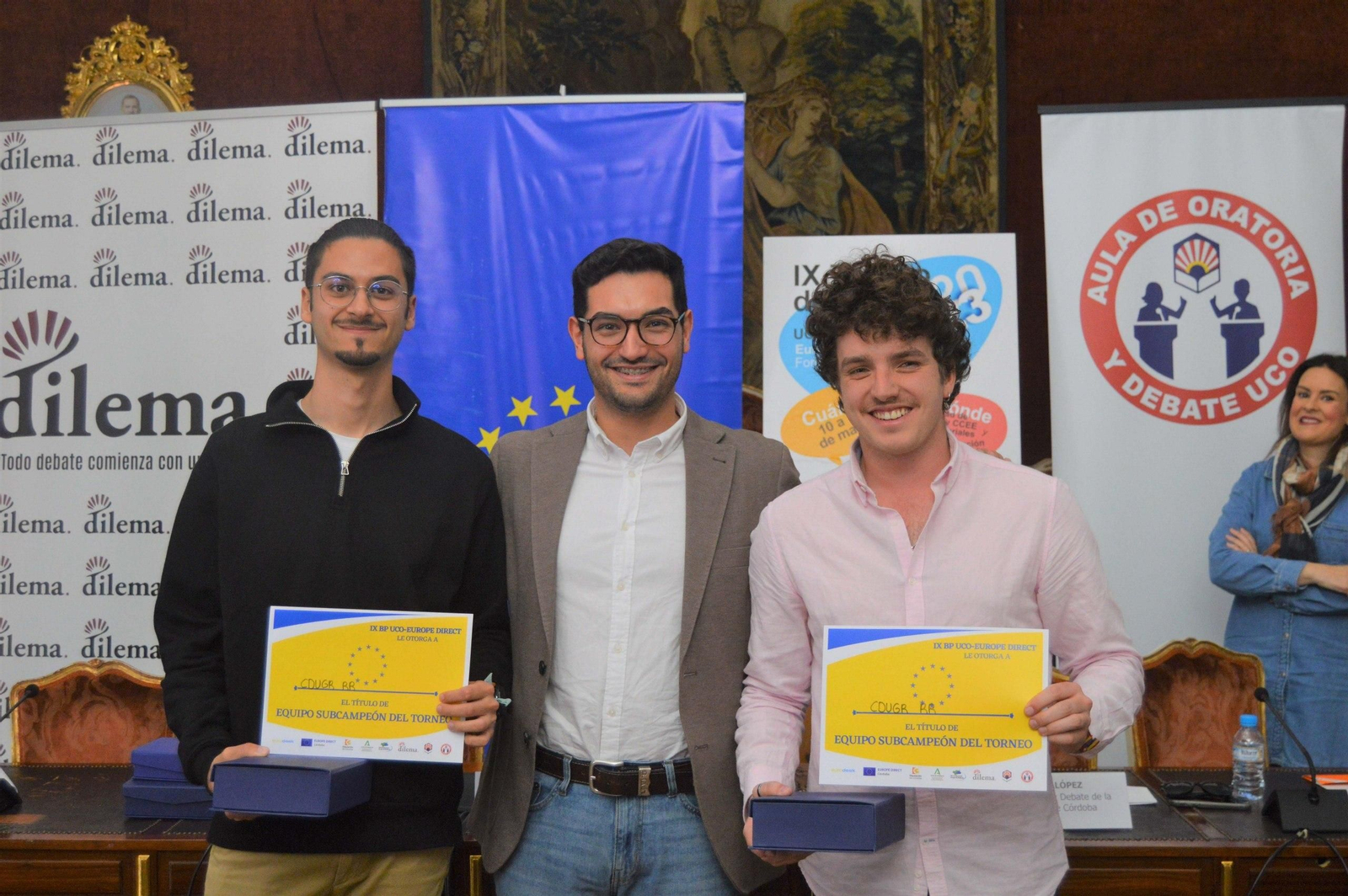 Los dos estudiantes de la UGR posan con su diploma.