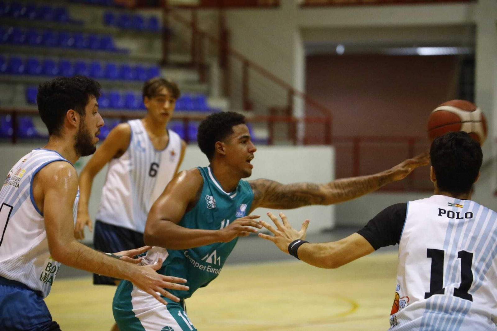 Sdenry González (UCB) es presionado por dos jugadores del Cimbis.