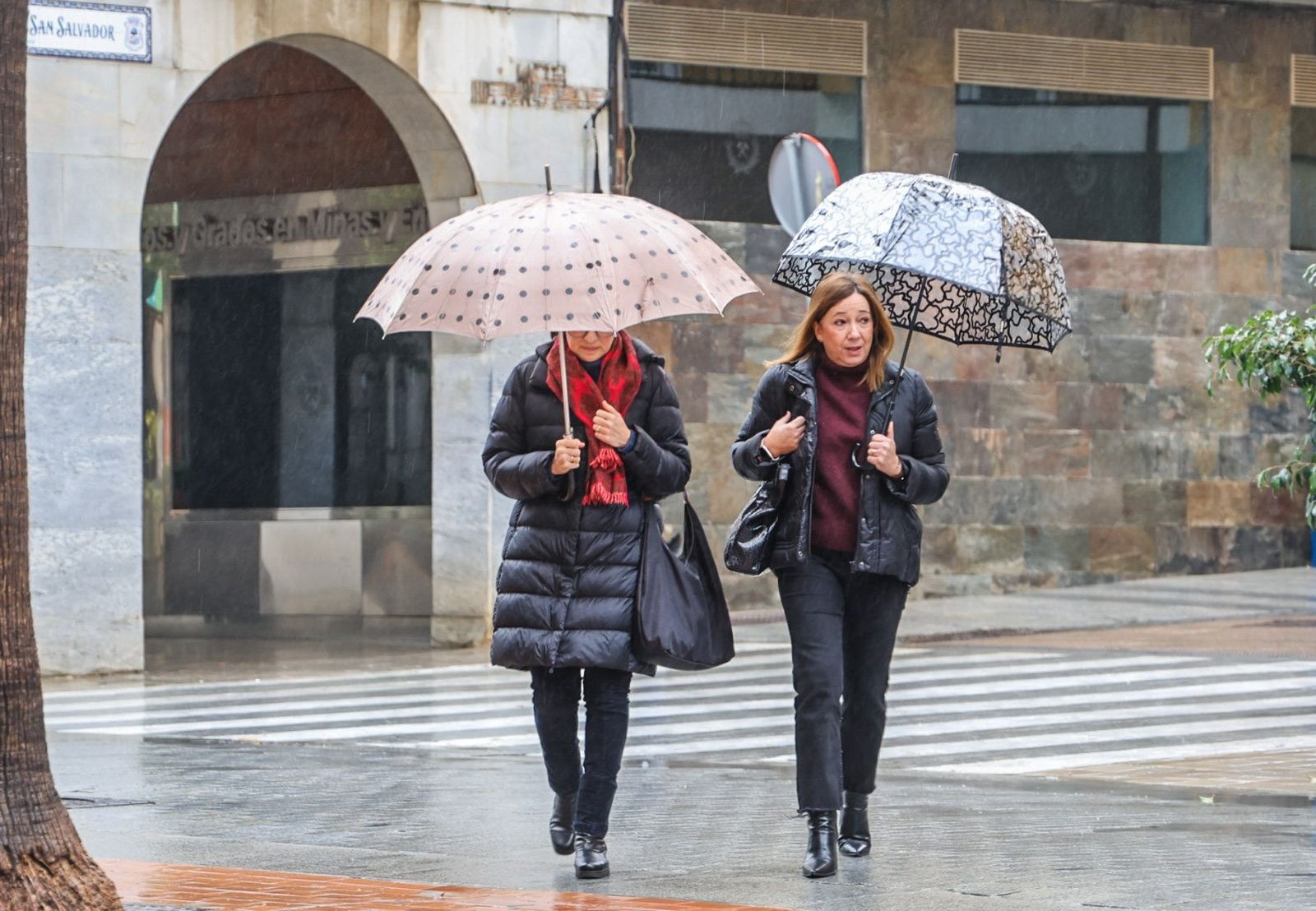 Dos personas paseando por Huelva en plena borrasca Ingrid.