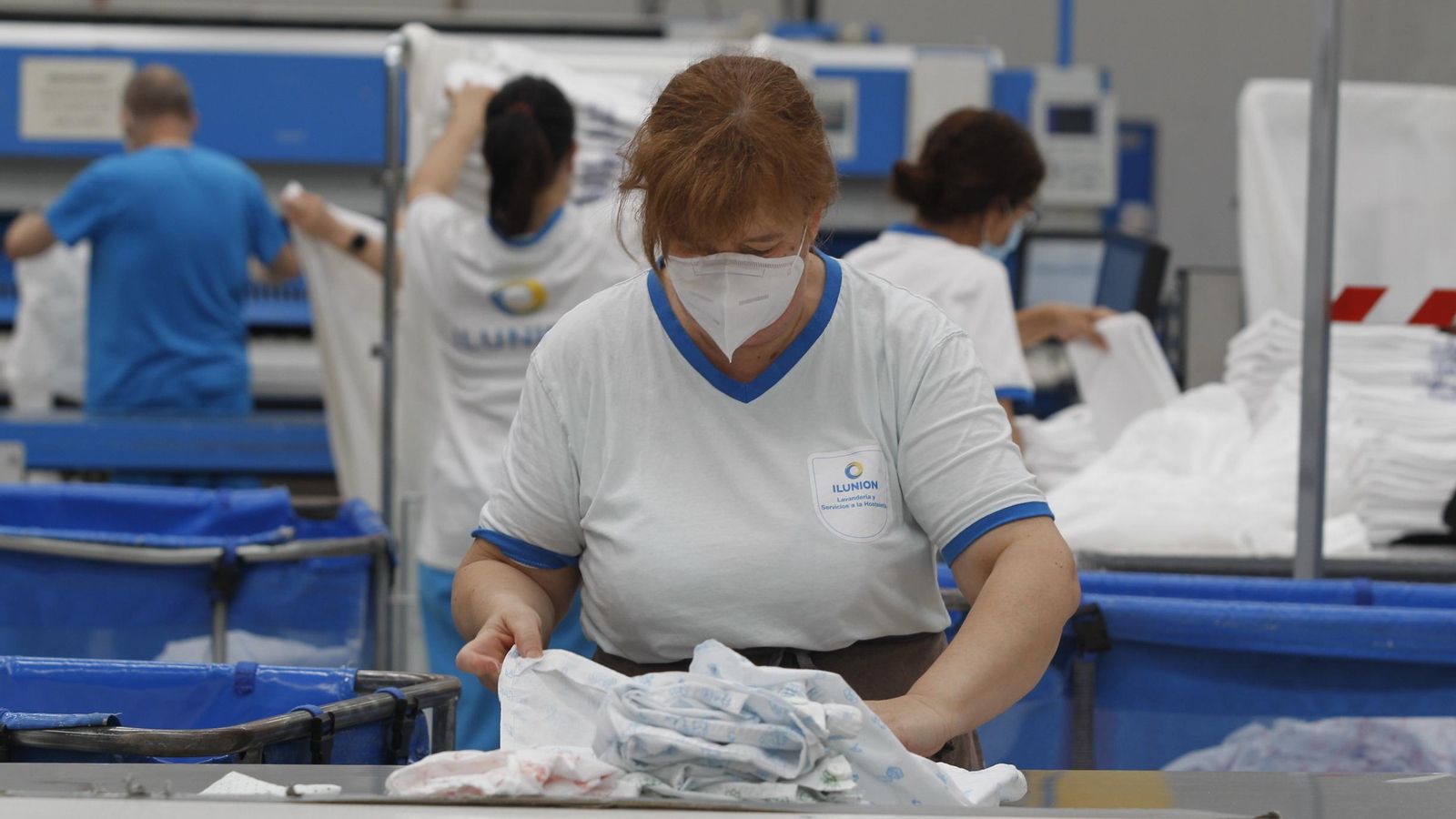 Una trabajadora de Ilunion durante las labores de planchado y doblado de los tejidos