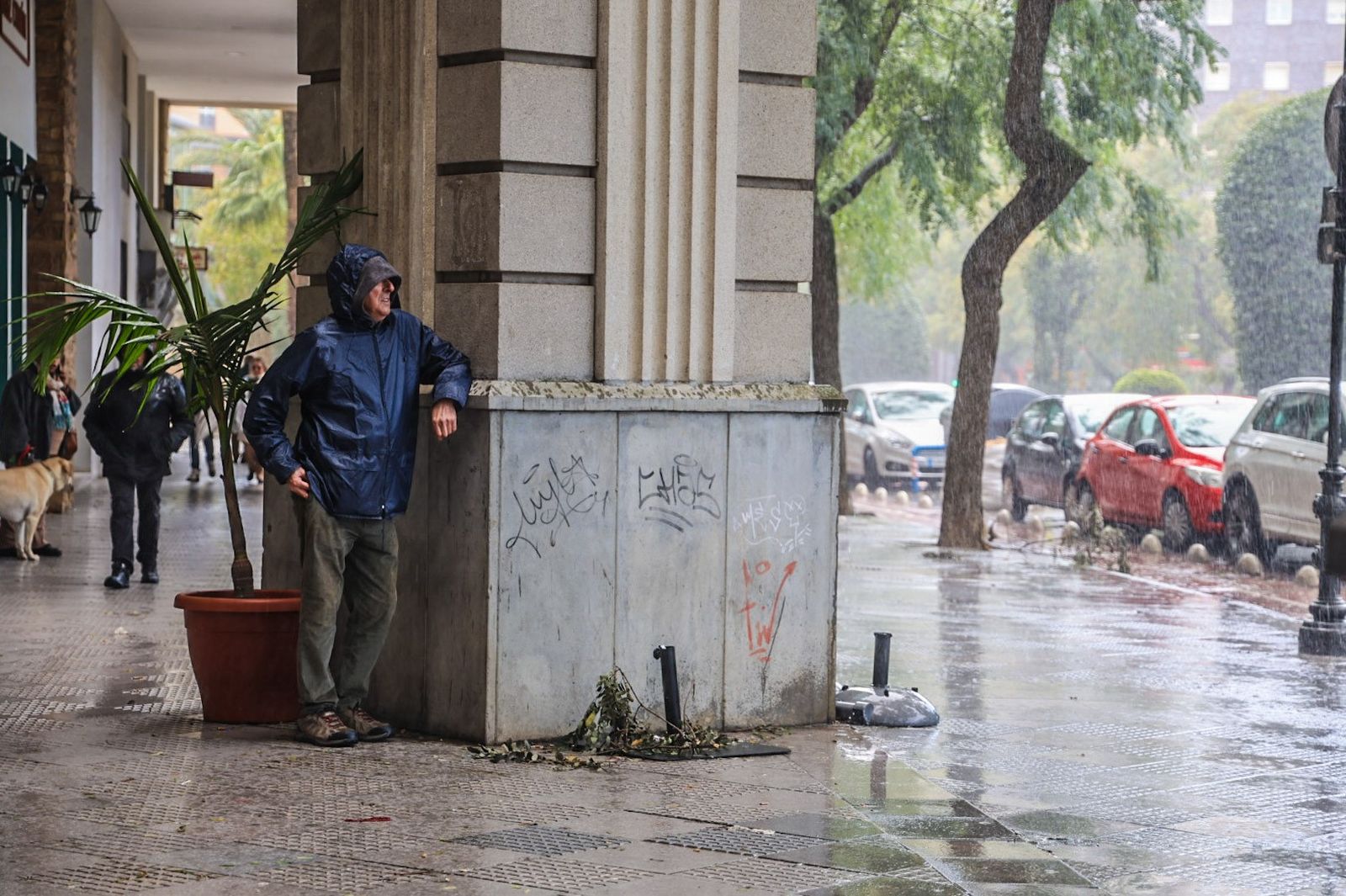 Un vecino espera a que amaine la lluvia en Huelva.