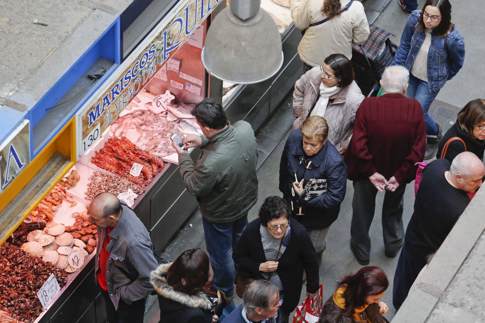 Varias personas compran en un puesto del mercado de Atarazanas, en Málaga capital.