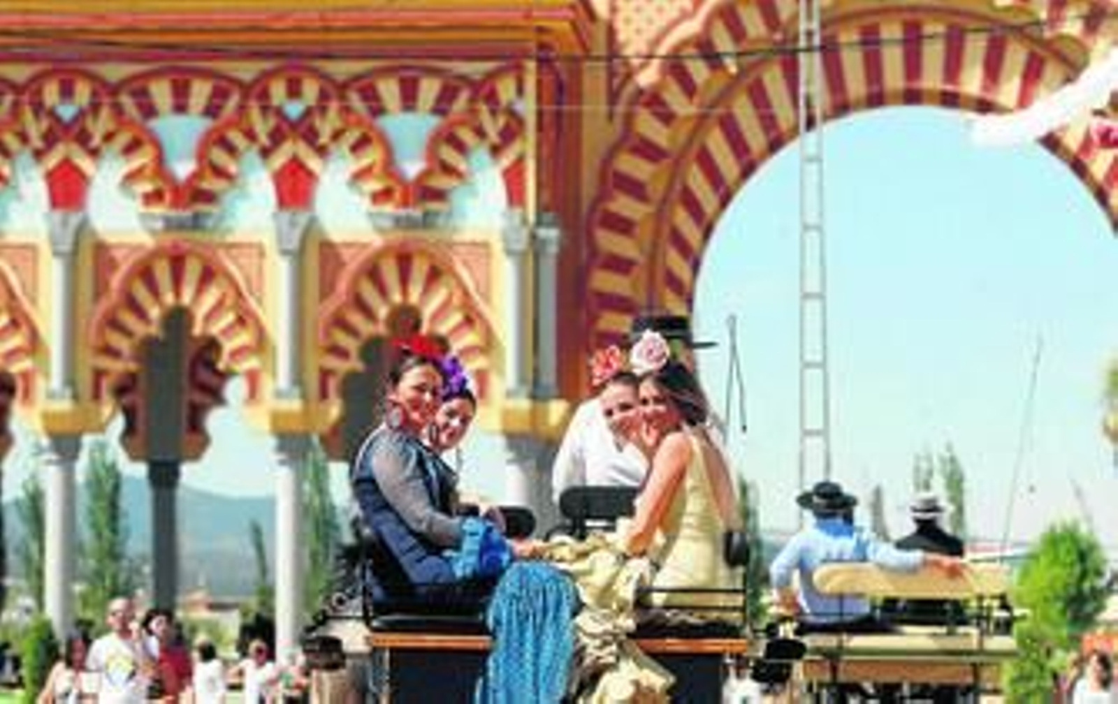 Unas jóvenes se pasean en coche de caballos por El Arenal en la Feria pasada.