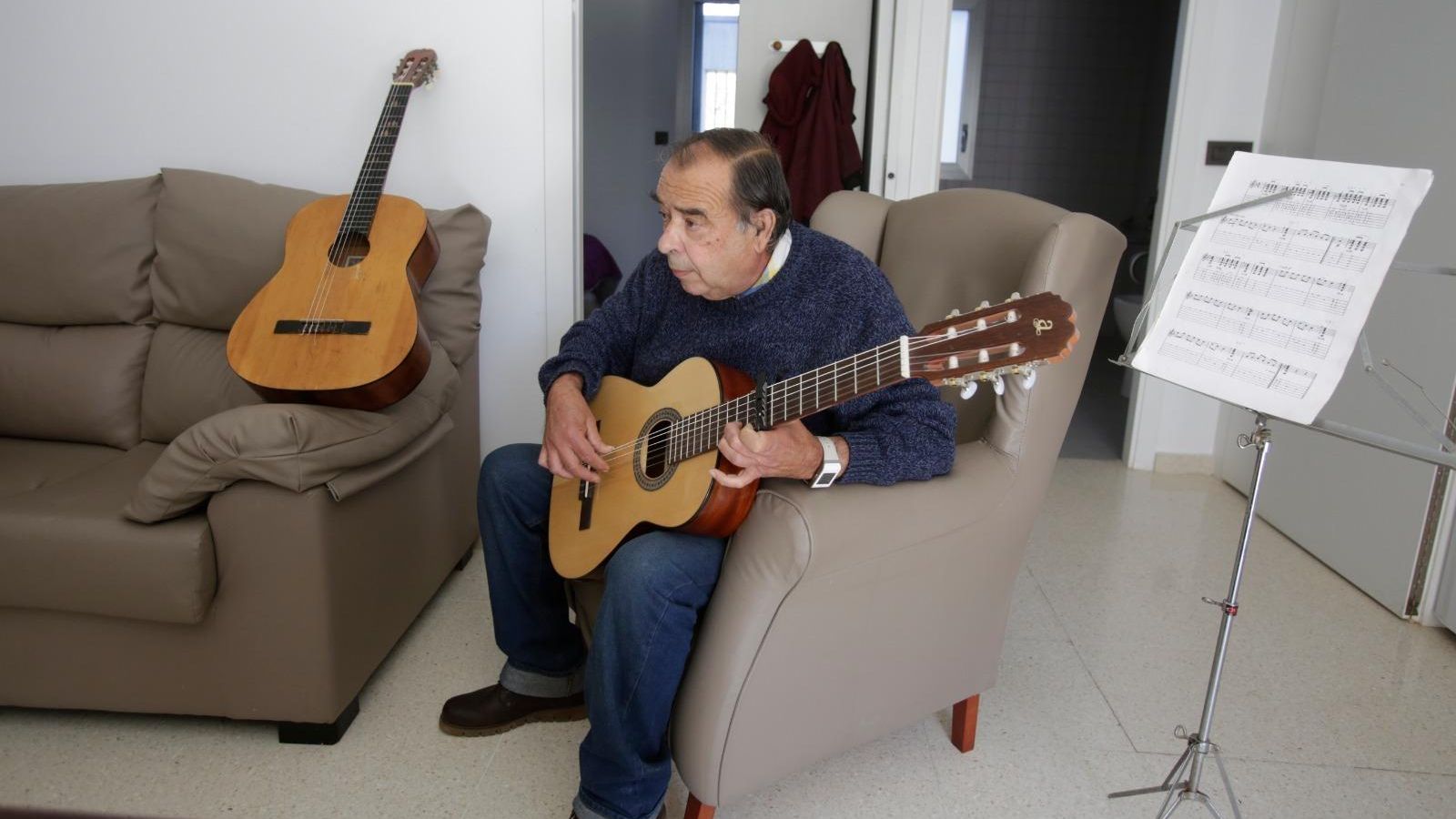 José Manuel Palma, uno de los residentes de RUE32, tocando la guitarra en su vivienda.